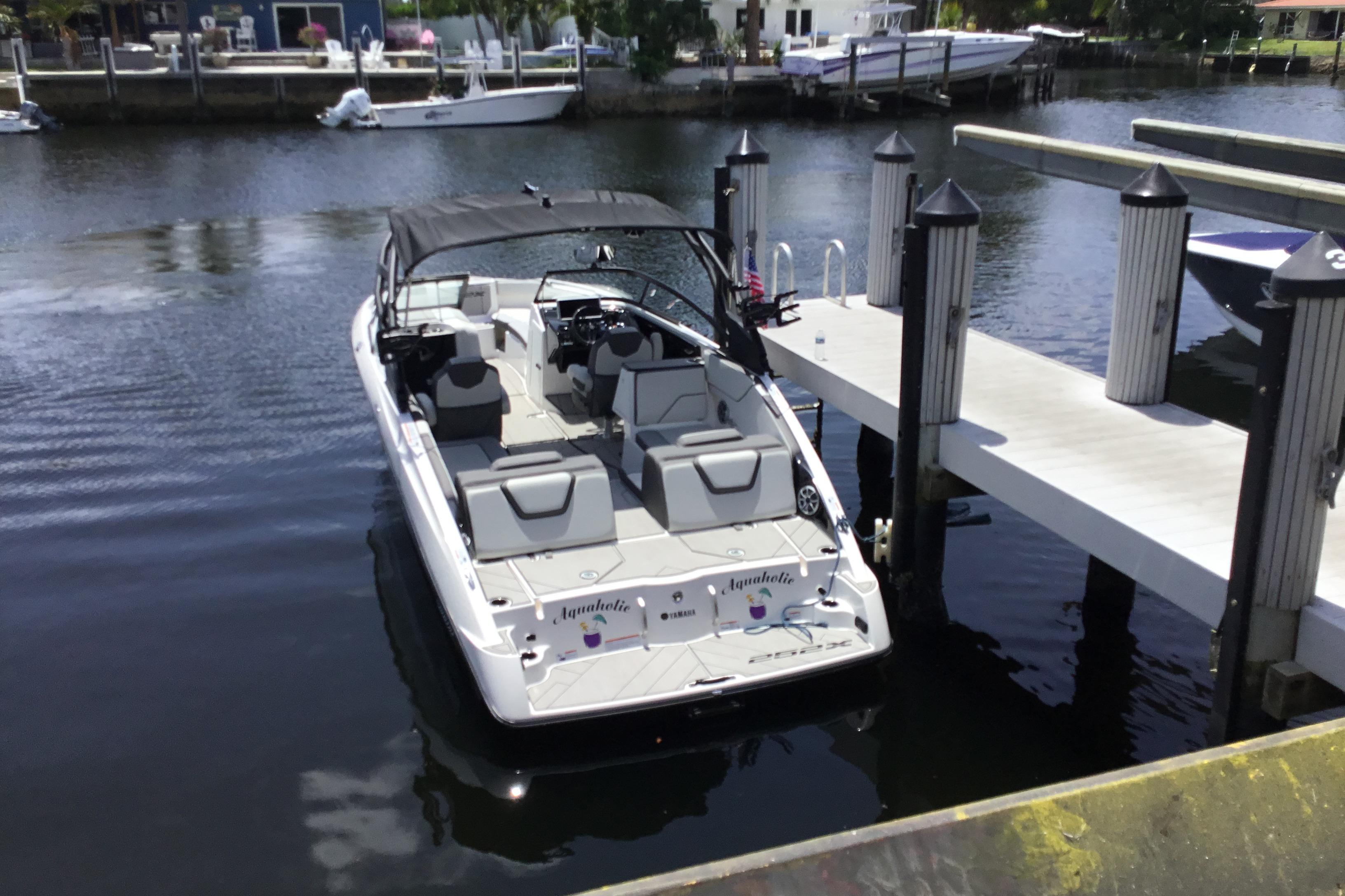 2023 Yamaha Boats 252XE docked at a marina, showcasing sleek design and modern features.