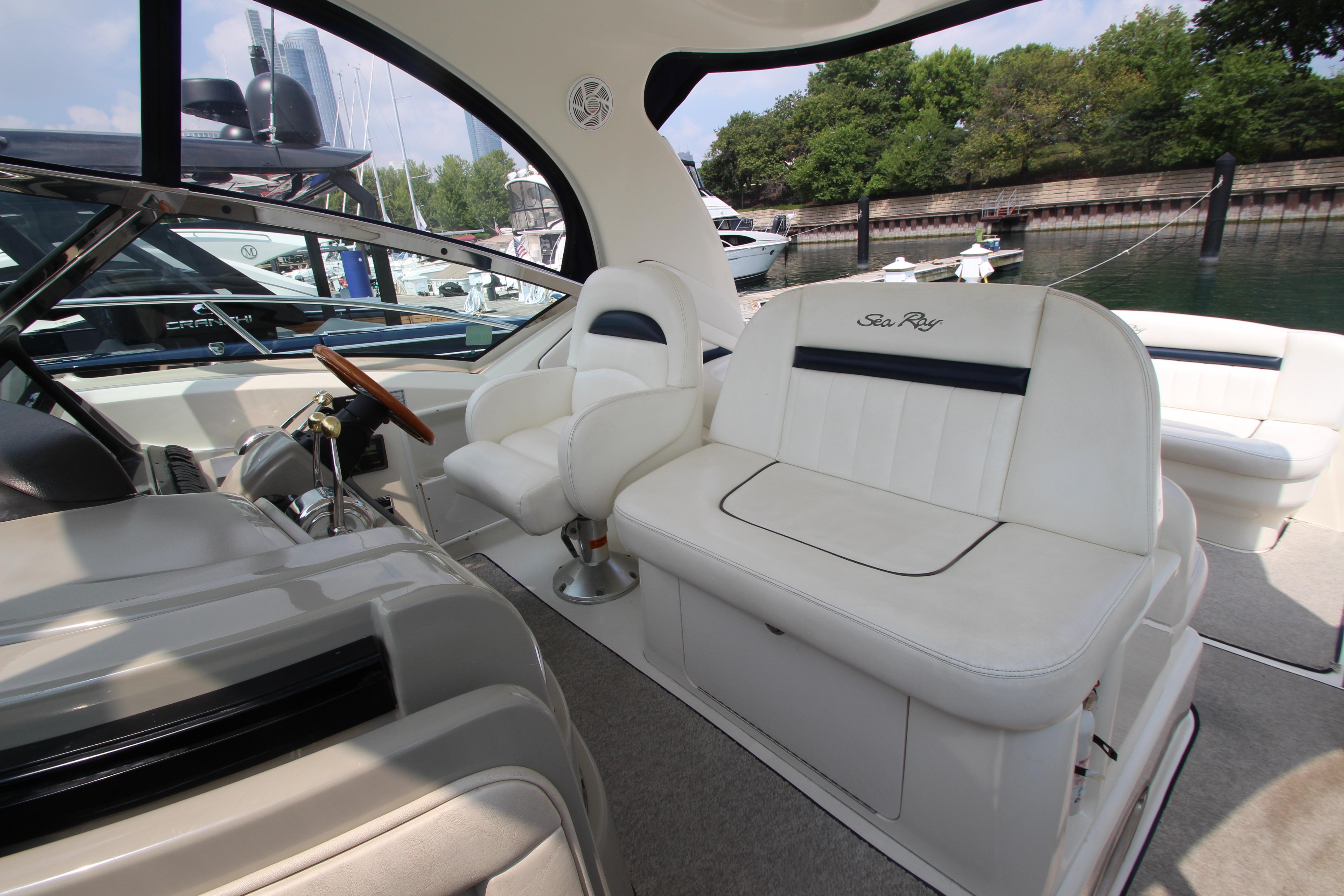 2004 Sea Ray 40 Sundancer interior with white seating and steering wheel, docked at marina.