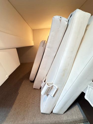 Cushioned interior of 2015 Sea Ray 260 Sundancer boat, featuring white upholstery.