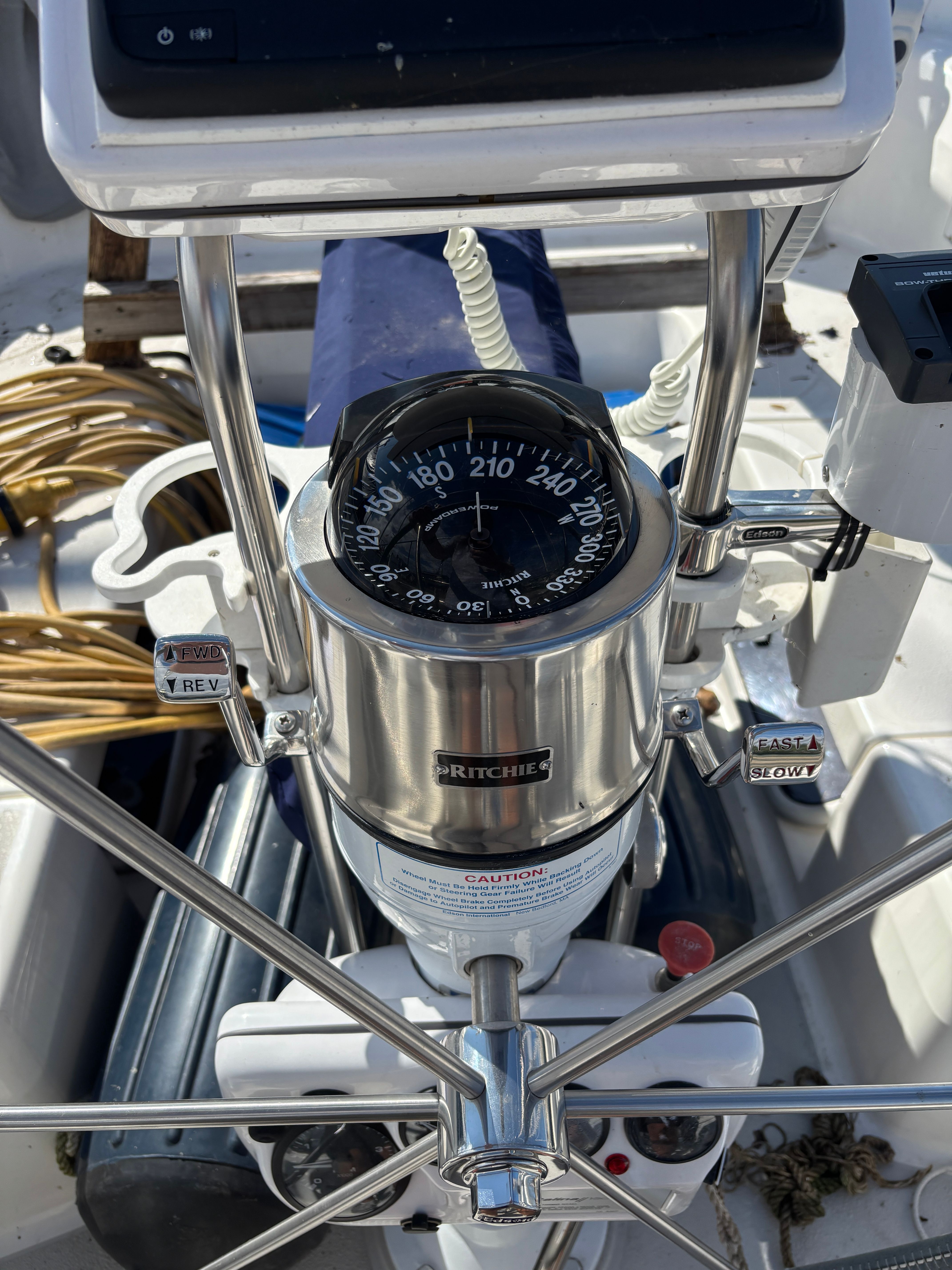 Steering wheel and compass on a 2000 Catalina 380 sailboat cockpit.