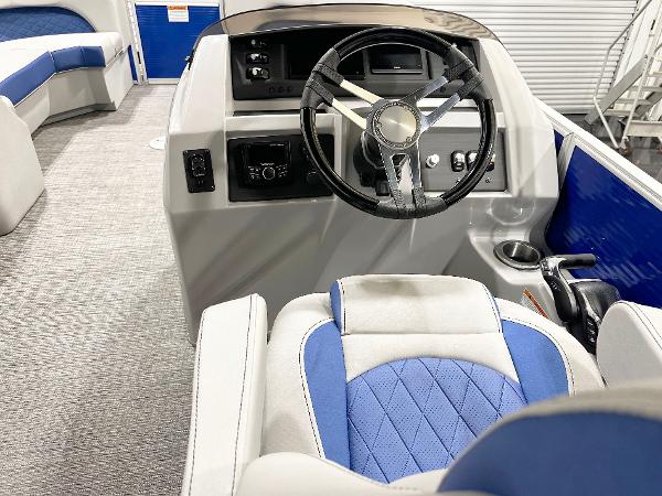 Interior of 2025 Bennington 23LFBCSR boat with steering wheel and blue seating.