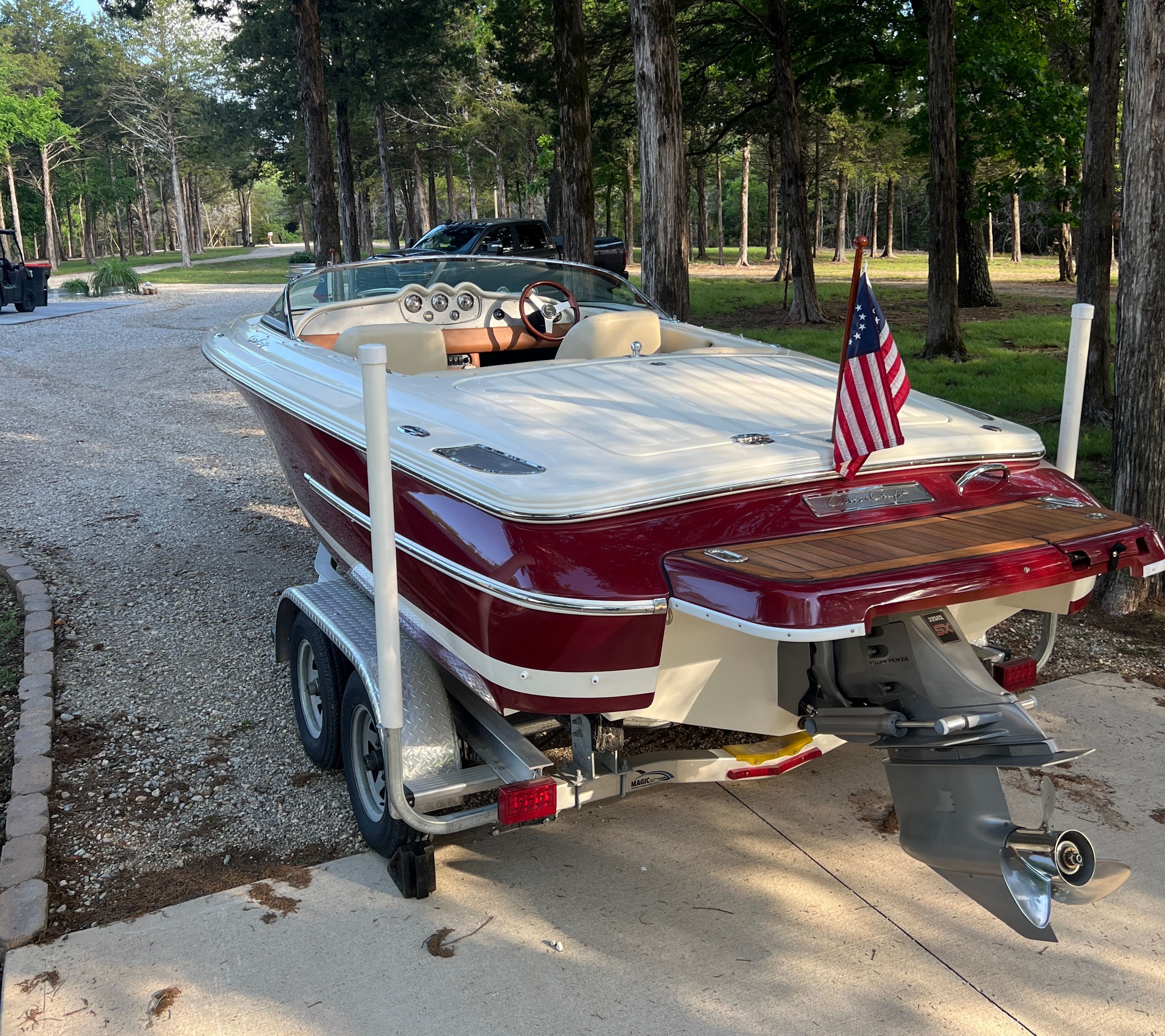 A 2006 Chris-Craft Speedster 20 on a trailer in a wooded area.