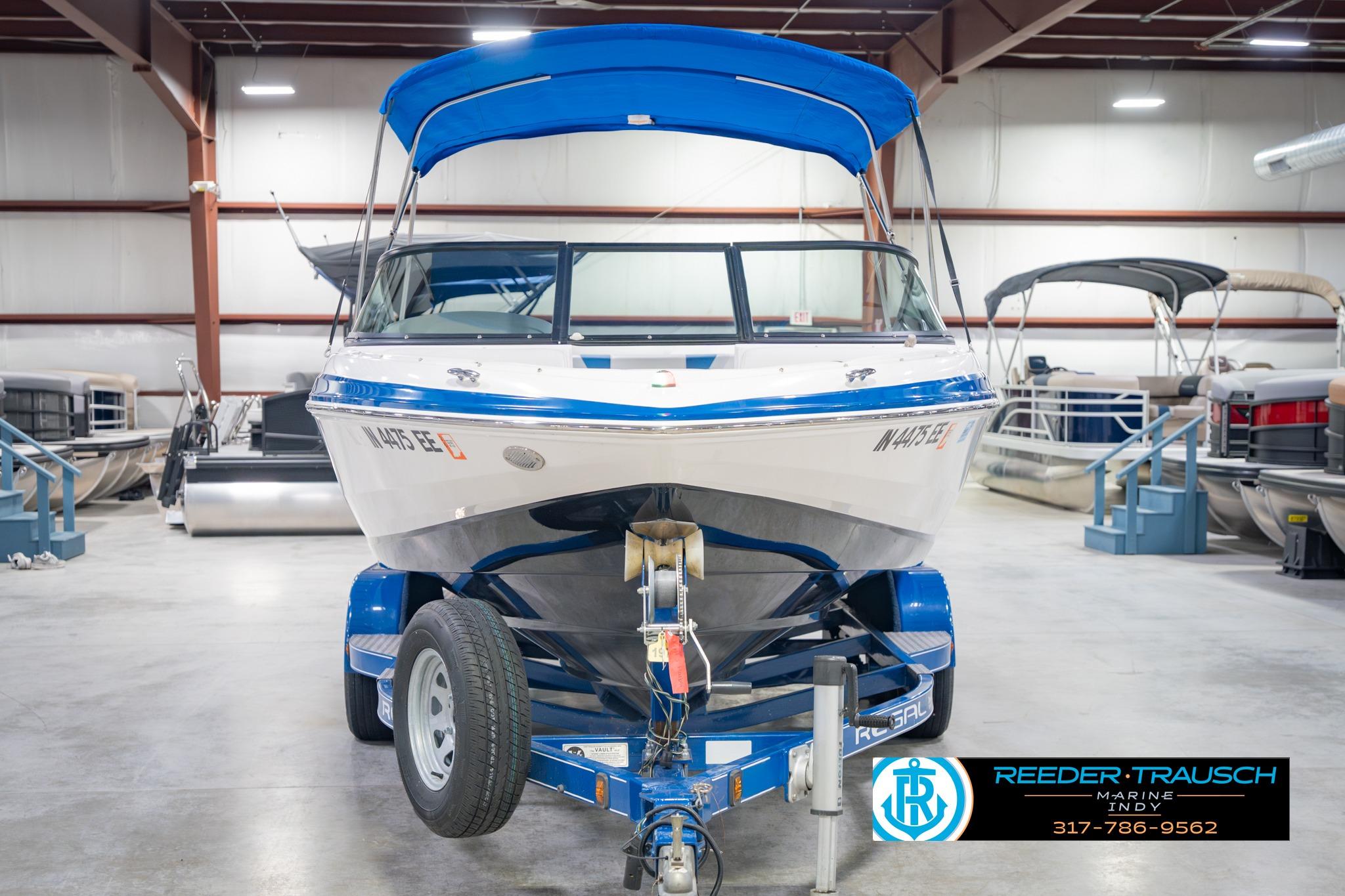 2015 Regal 2000 ESX Bowrider with blue canopy on trailer in showroom.