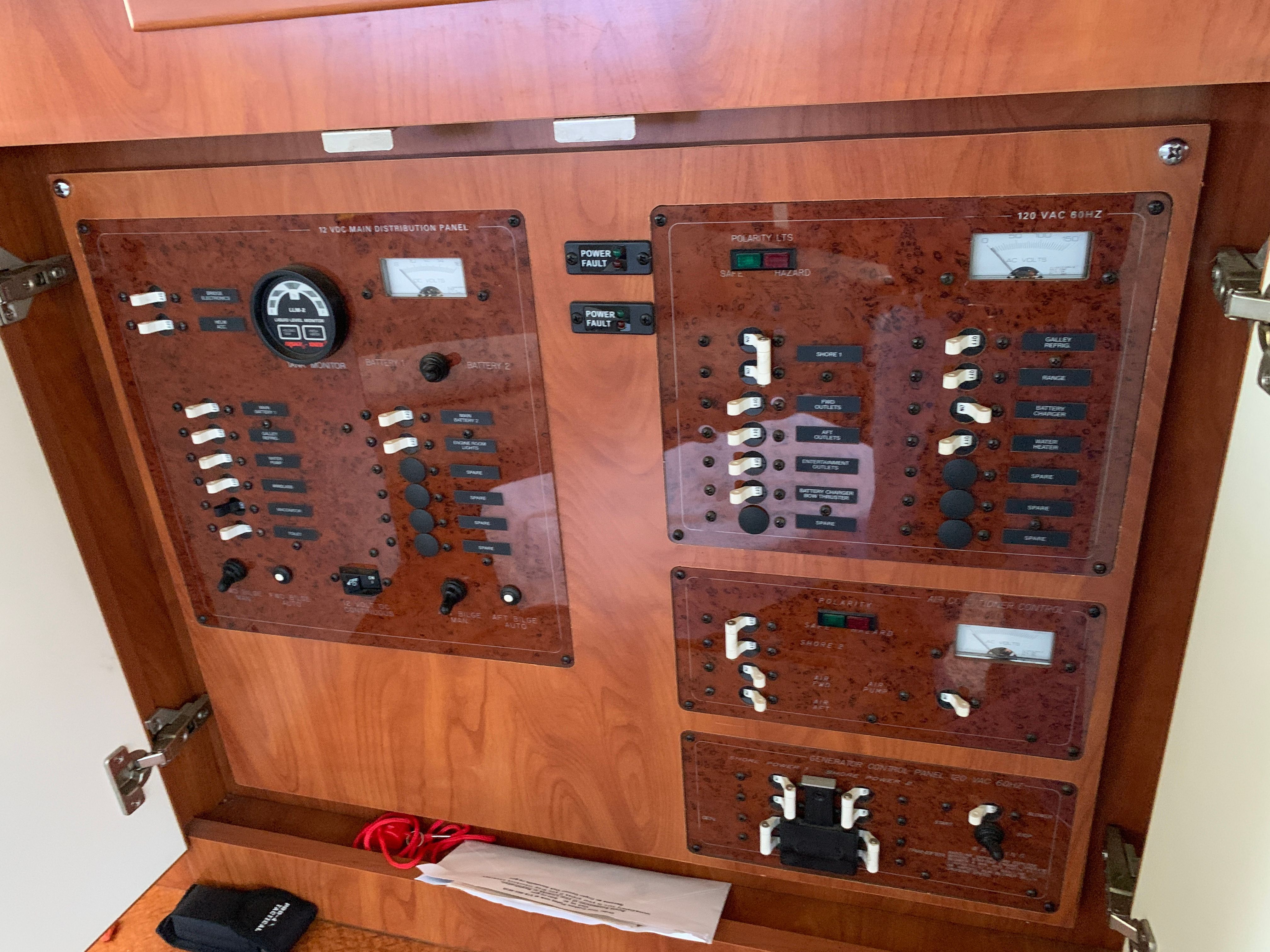 Electrical control panel with switches and gauges on a boat.
