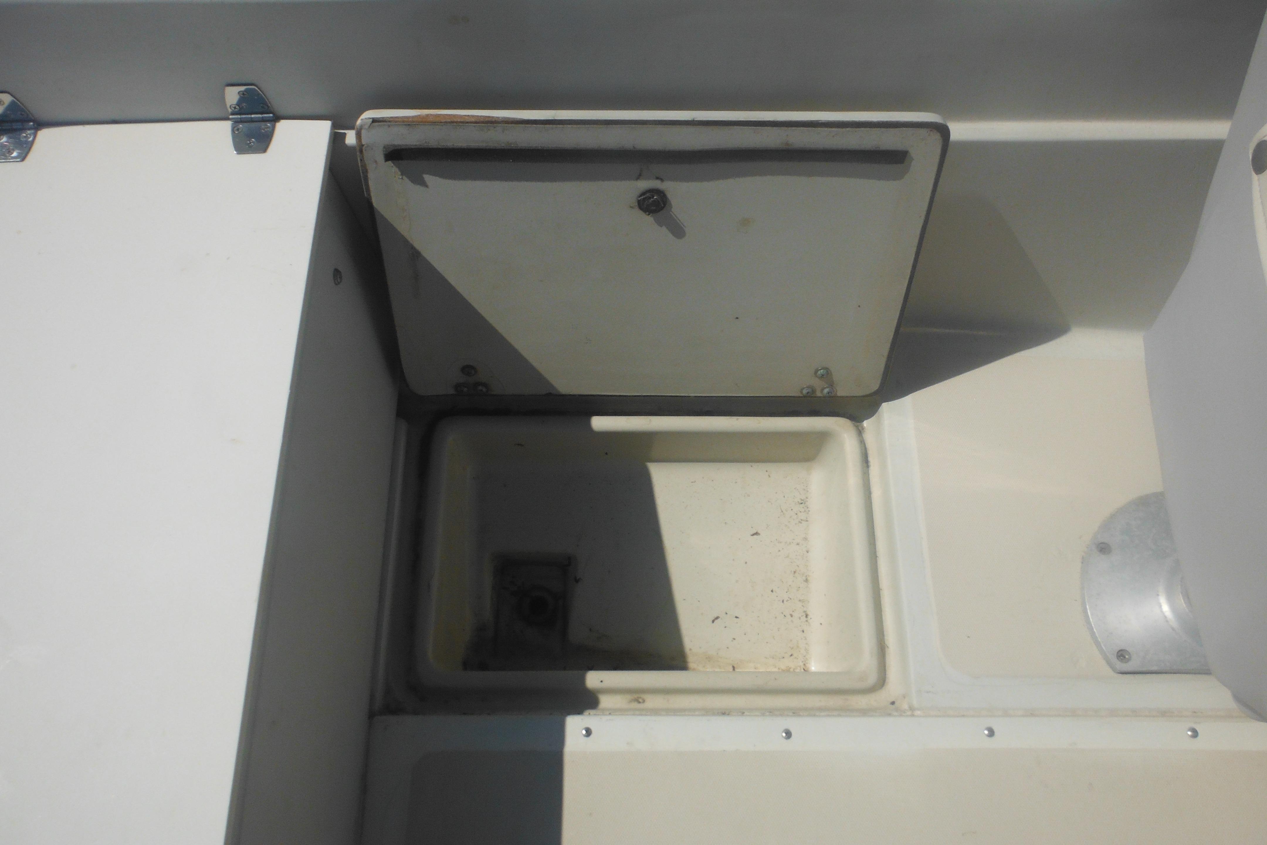 1991 Boston Whaler 16 SL boat storage compartment with open hatch, showcasing interior space.