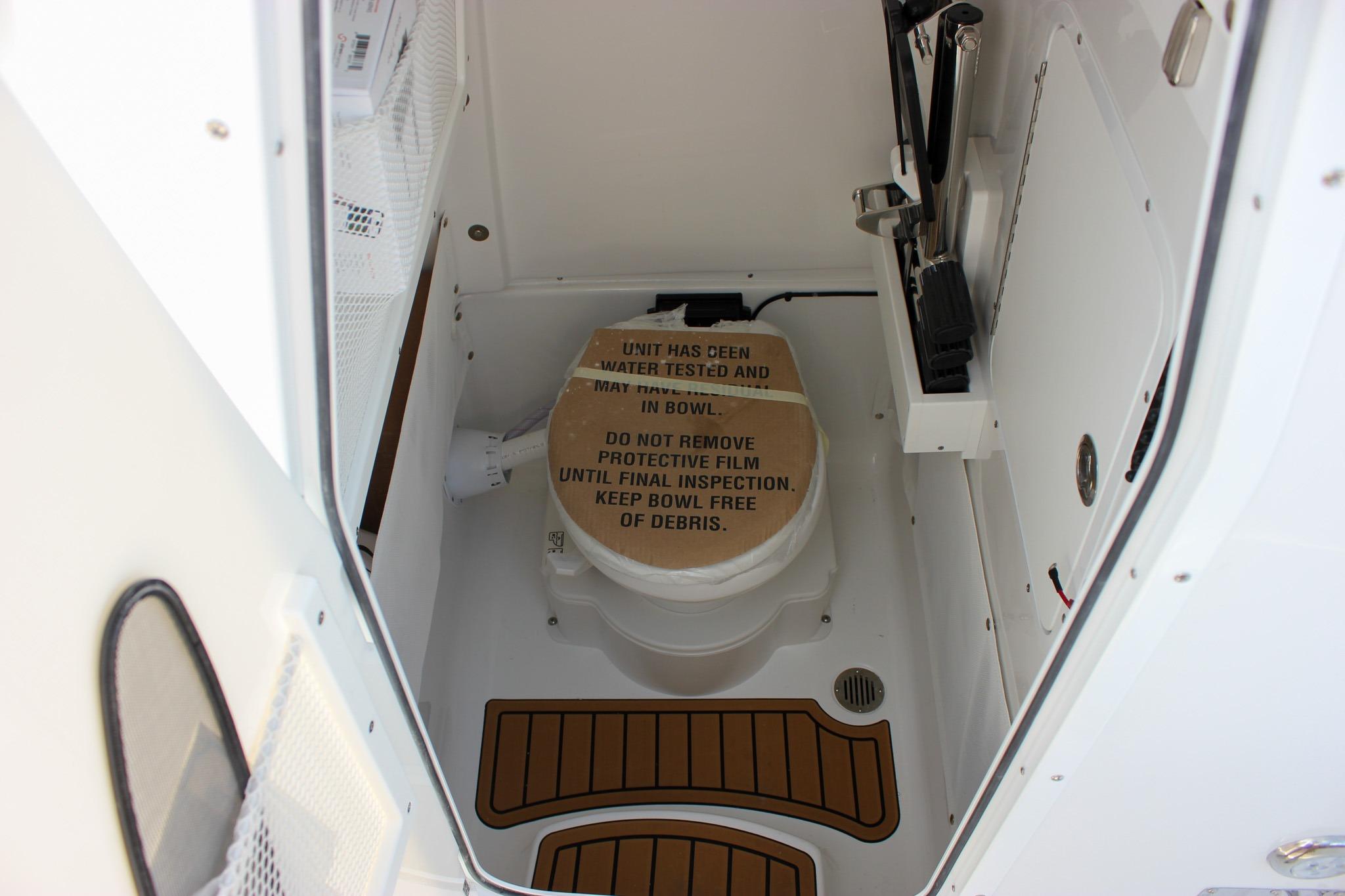 2027 Sea Hunt Ultra 275 SE boat interior with protective film on toilet.