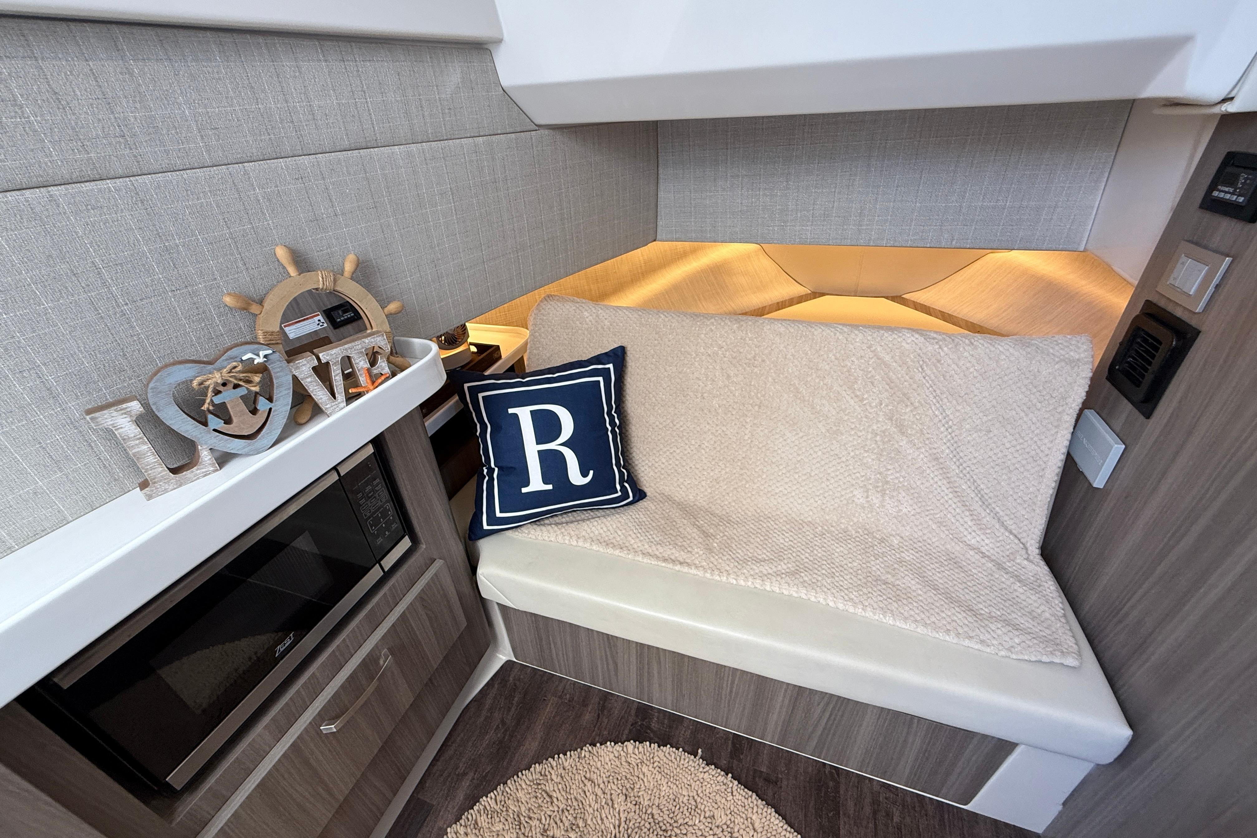 2022 Regal 38 SAV interior with cozy seating, decorative pillow, and nautical decor.