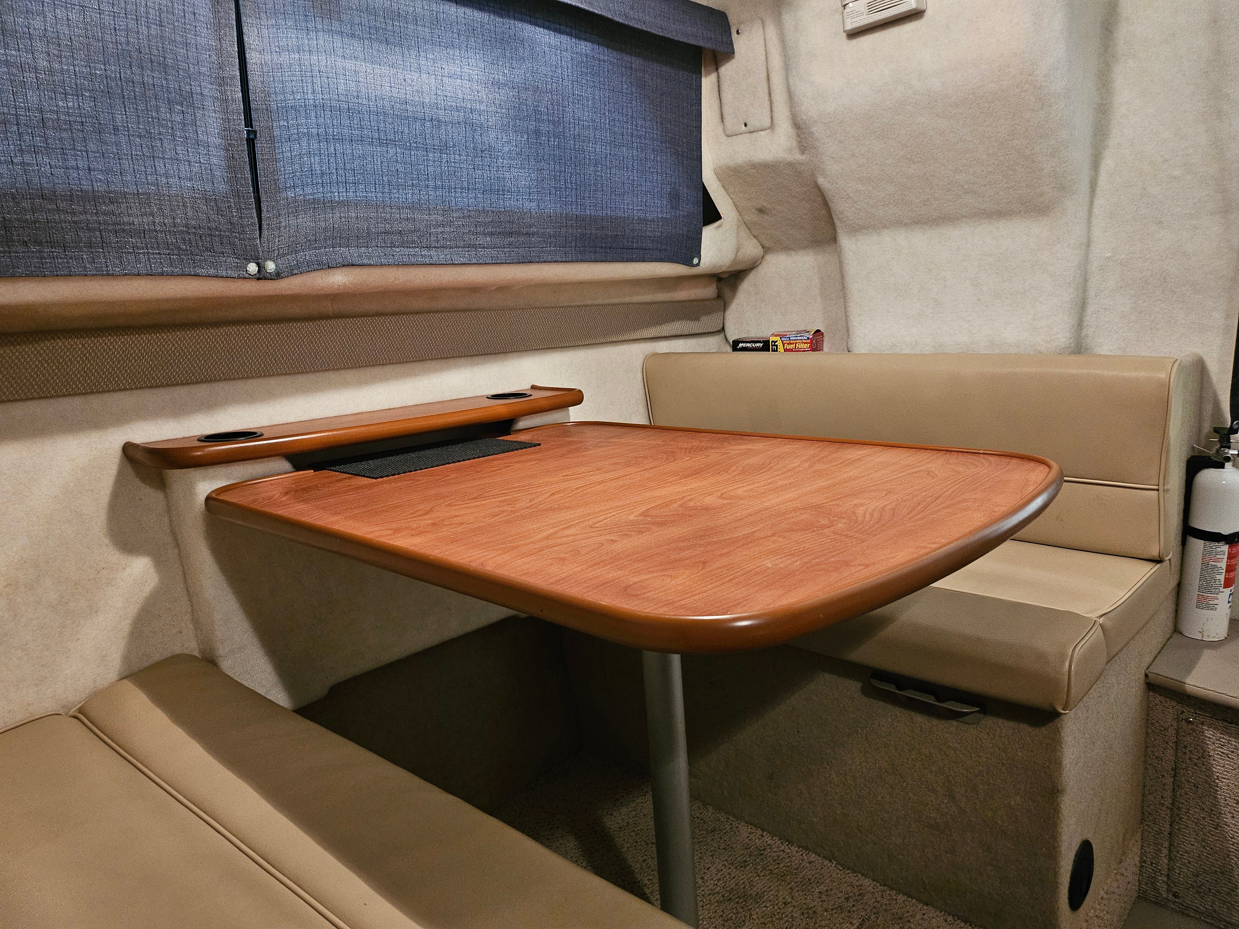 Interior of the 2005 Bayliner 242 Ceara with table and seating.