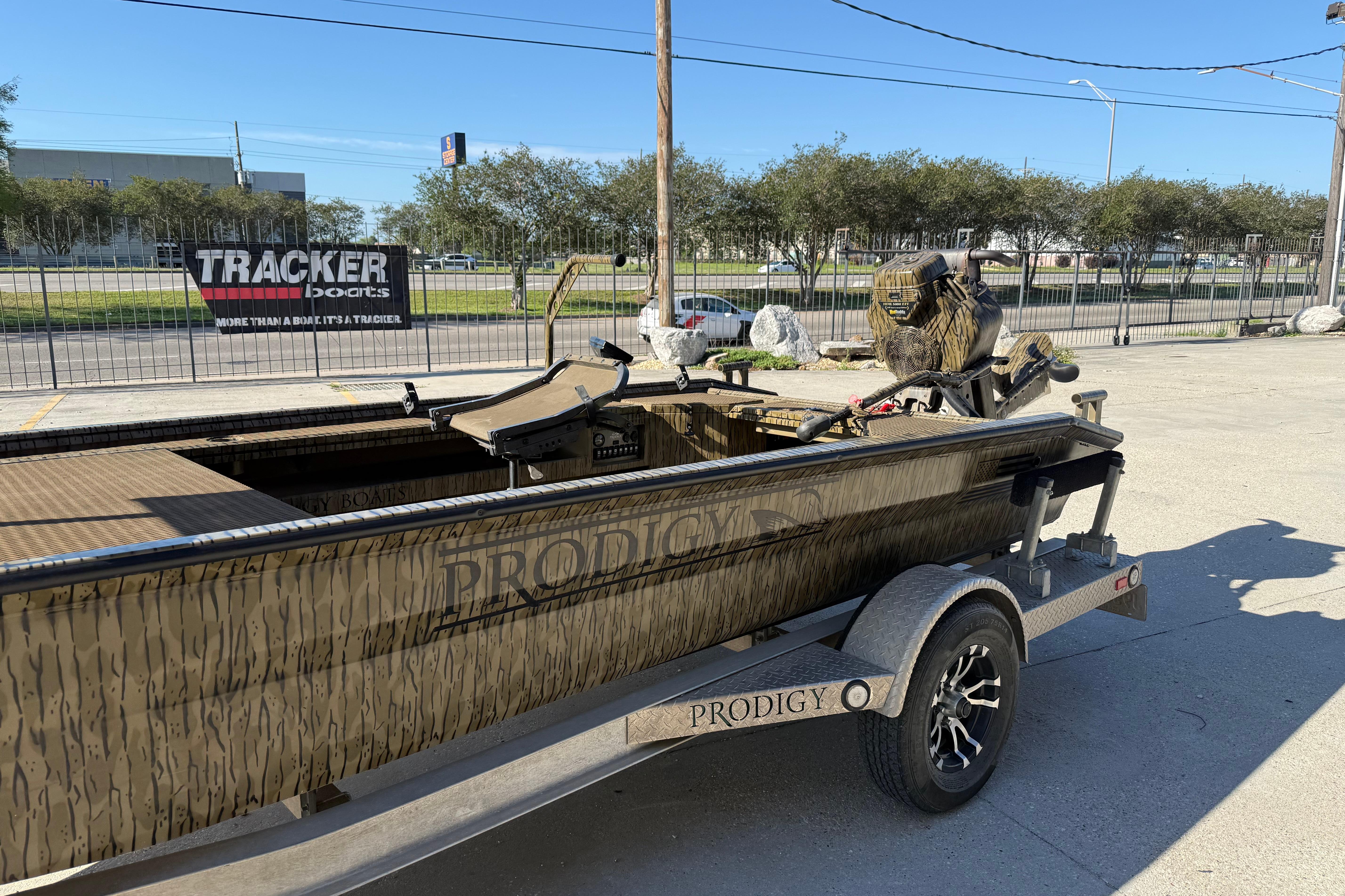 2022 Prodigy 1854 boat on trailer, parked outdoors, with camo design and motor.