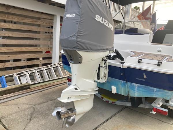 2006 Hurricane SunDeck 237 OB with Suzuki outboard motor, parked on a trailer.
