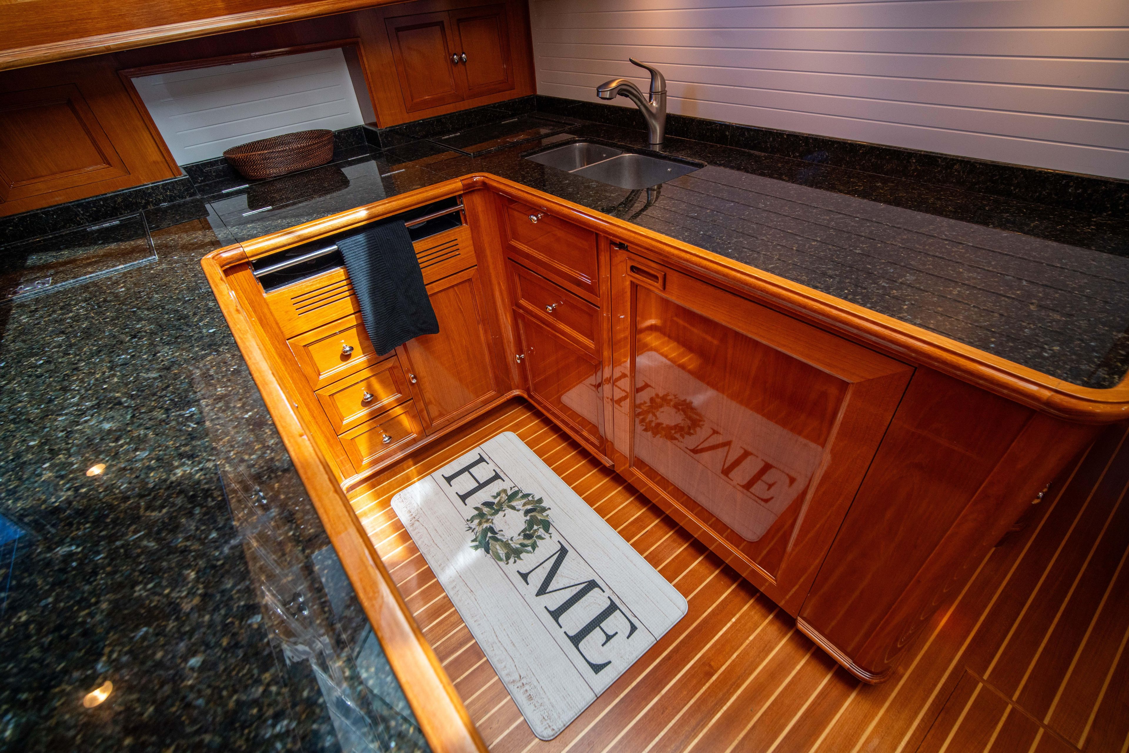 Luxurious kitchen area in a 2004 Grand Banks 58 Eastbay FB yacht, featuring wood cabinetry.