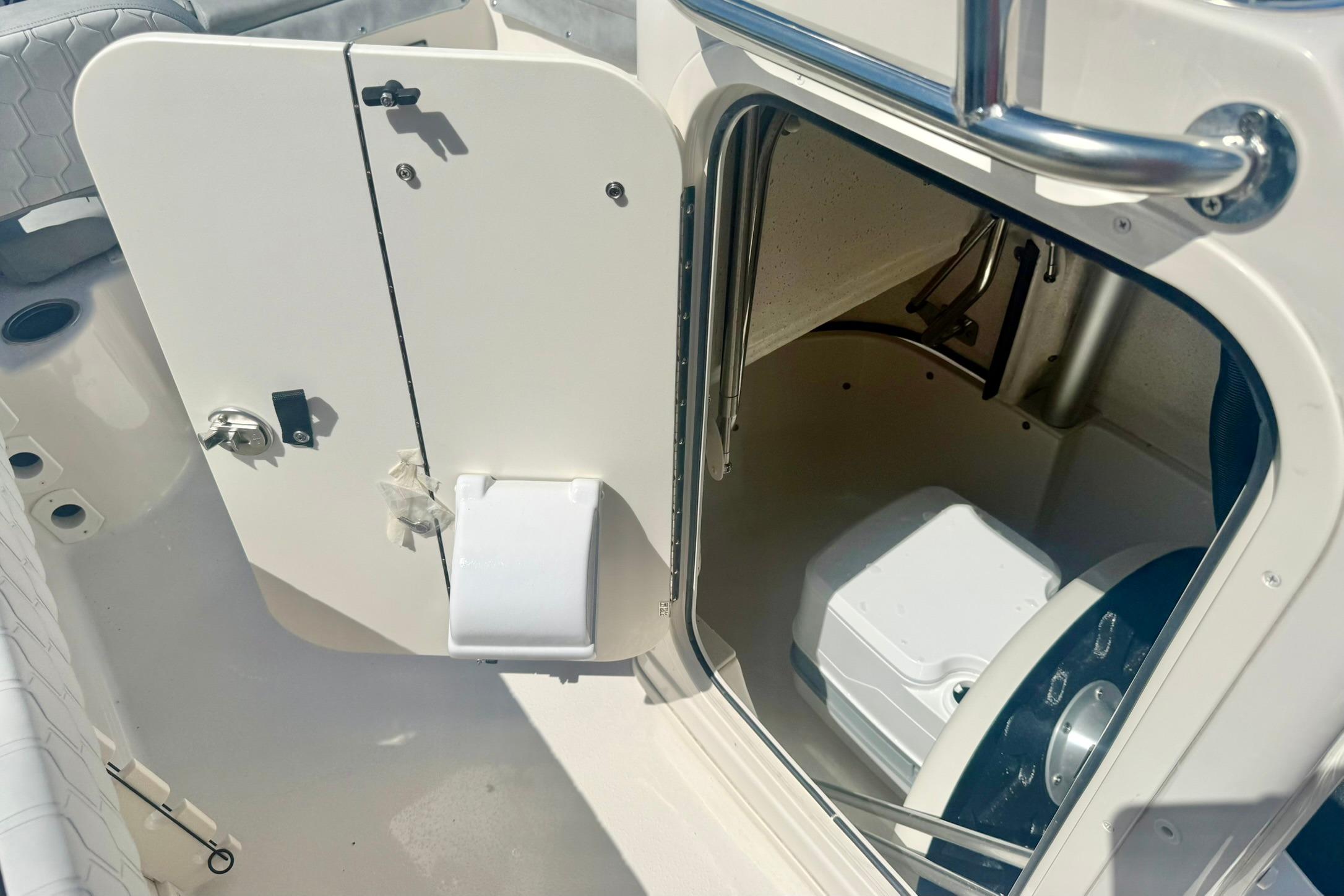 2026 Carolina Skiff 21 Ultra Elite boat interior with storage compartment and toilet.
