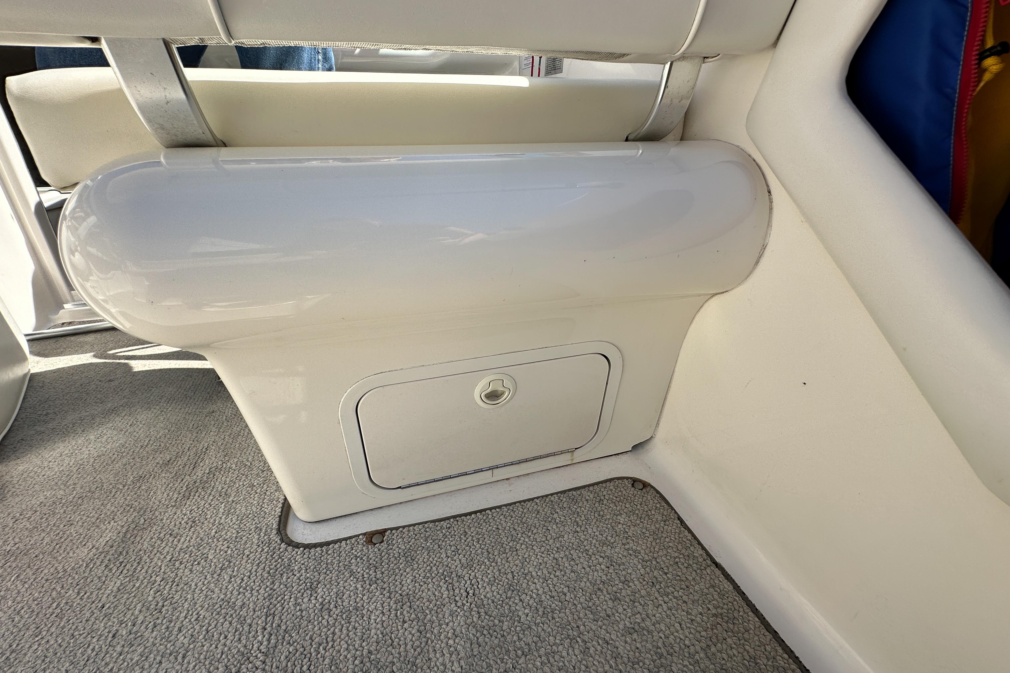 1998 Sea Ray 215 Express Cruiser interior storage compartment with cushioned seating.
