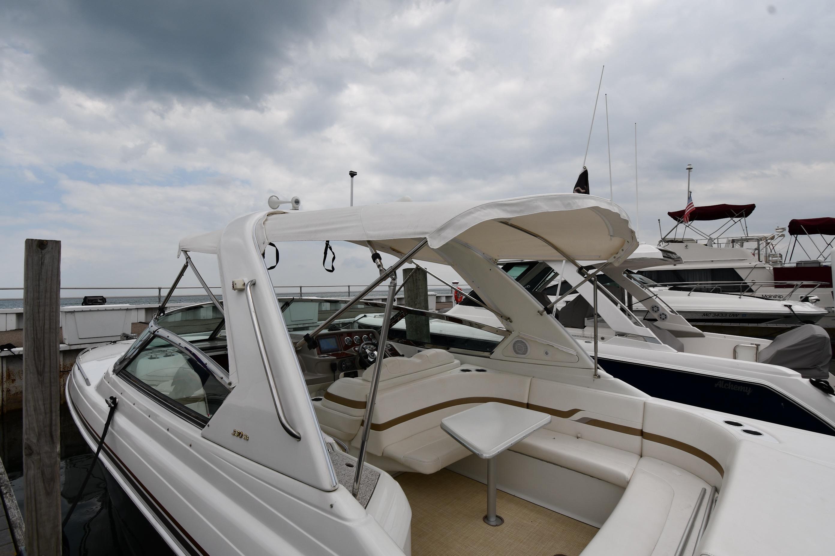 2004 Formula 330 Sun Sport boat docked under cloudy skies.