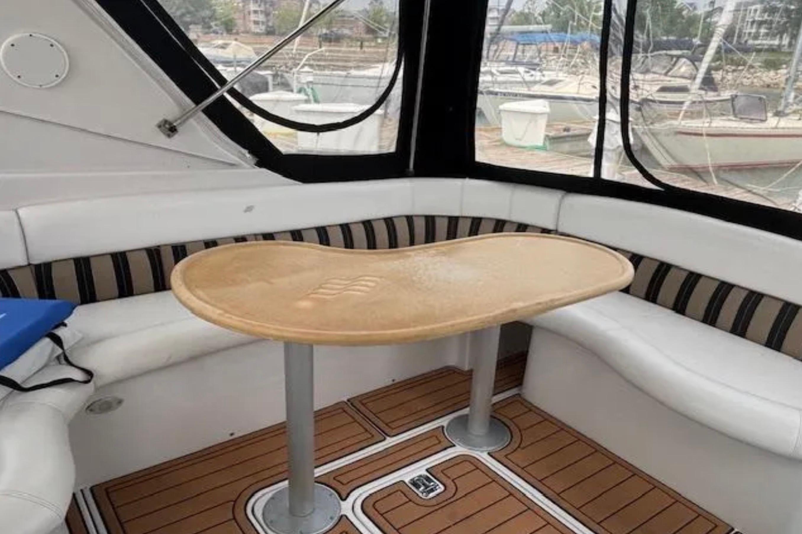 2007 Four Winns 378 Vista boat interior with curved seating and wooden table.