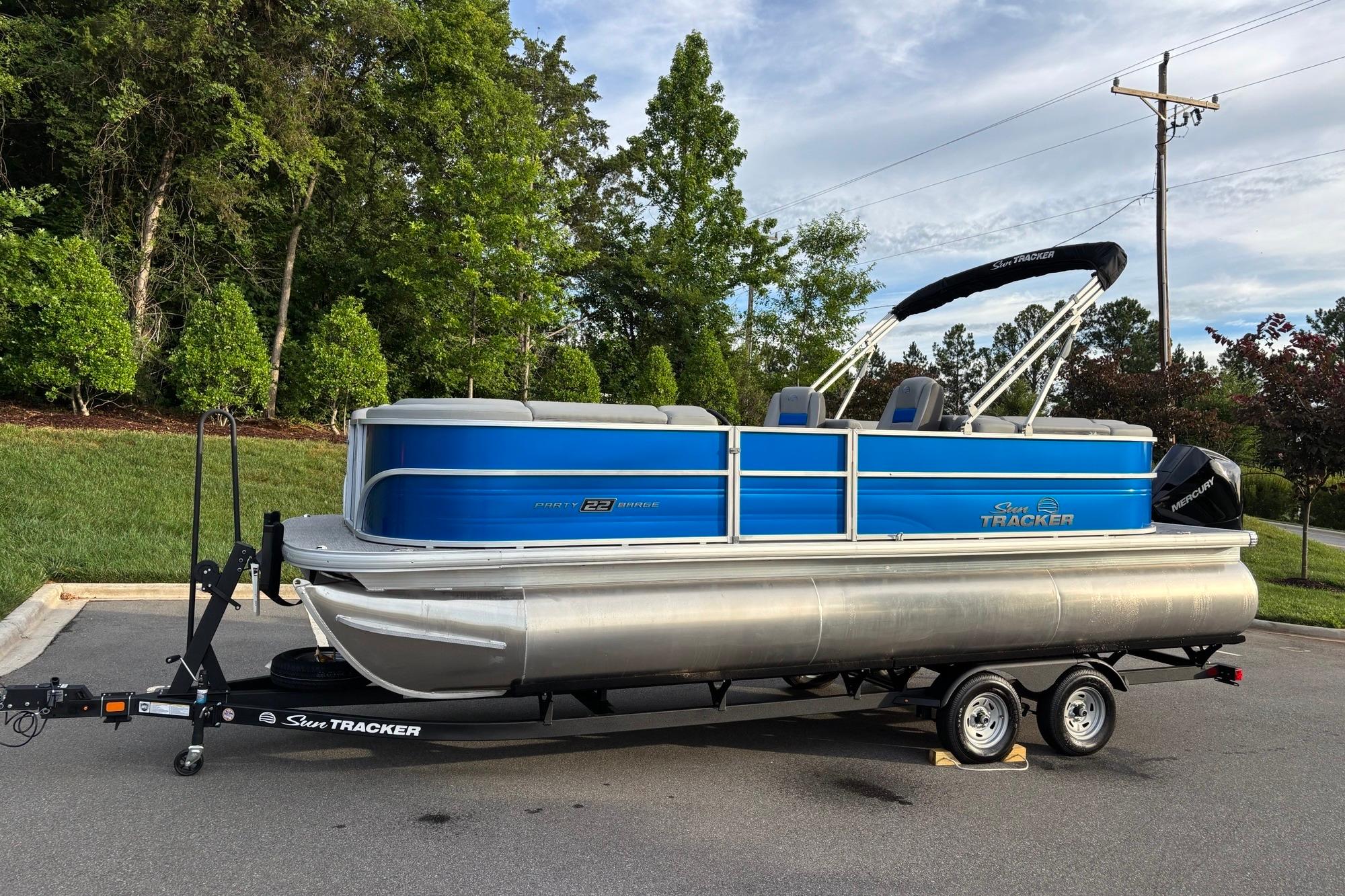2026 Sun Tracker Party Barge 22 XP3 pontoon boat on trailer, parked outdoors.