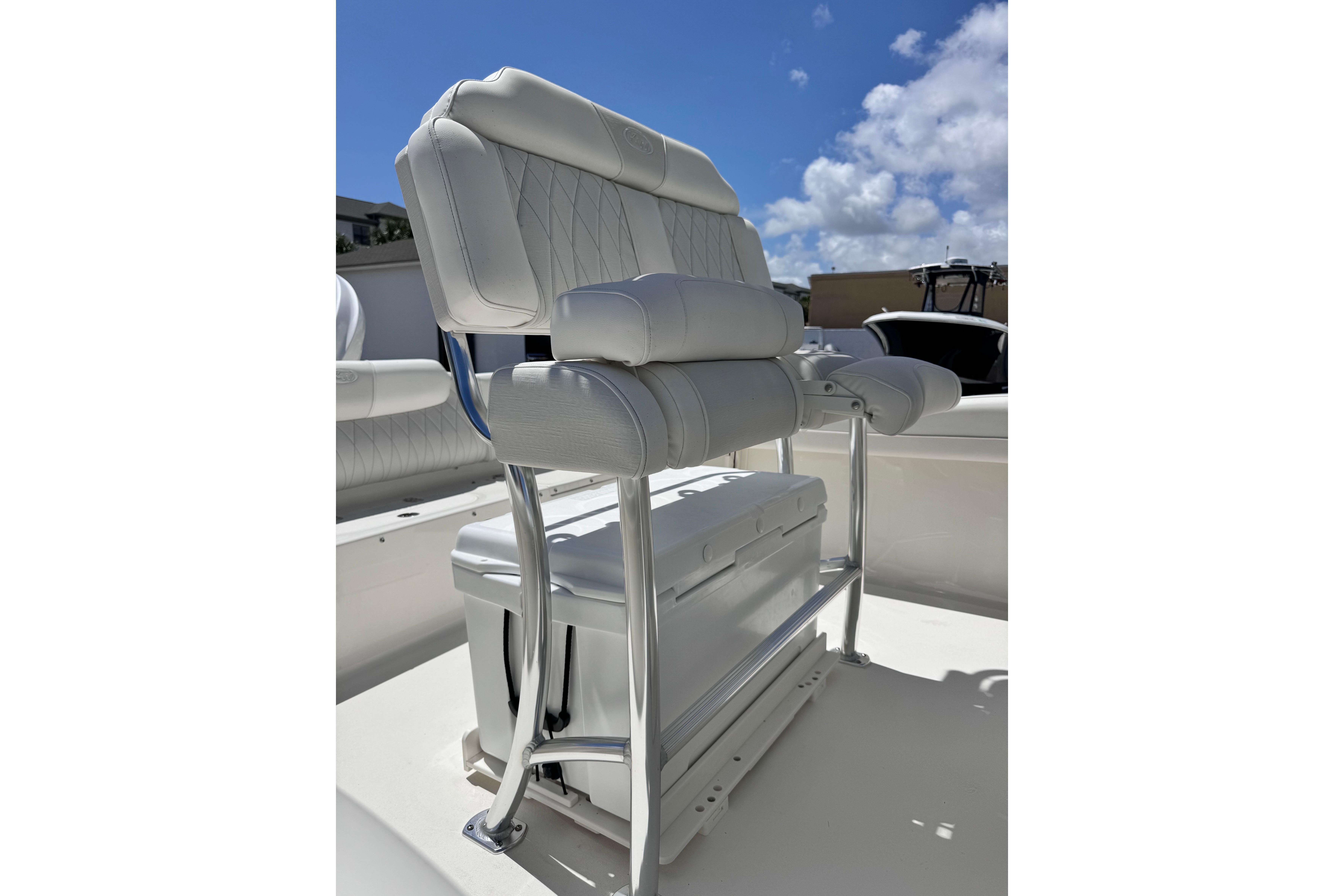 2026 Key West 219 FS boat seat with cushioned backrest and storage, under a clear blue sky.
