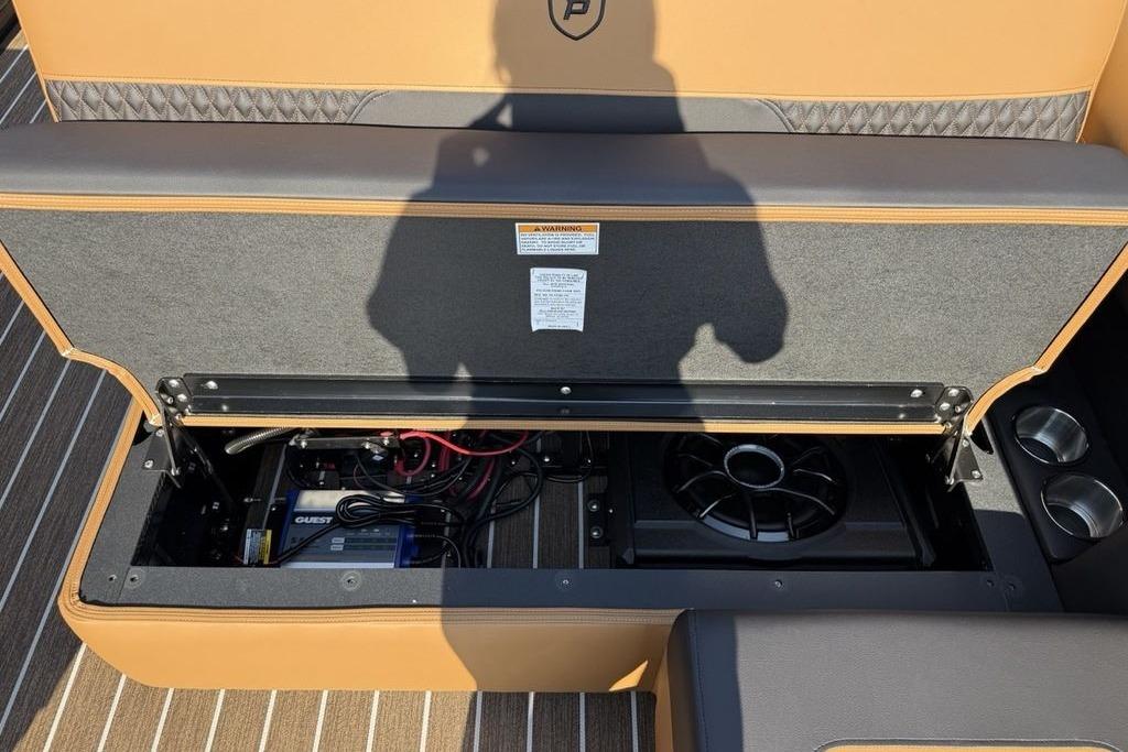 Open storage compartment in 2026 Premier 250 Solaris RS CL boat, revealing wiring and speaker system.