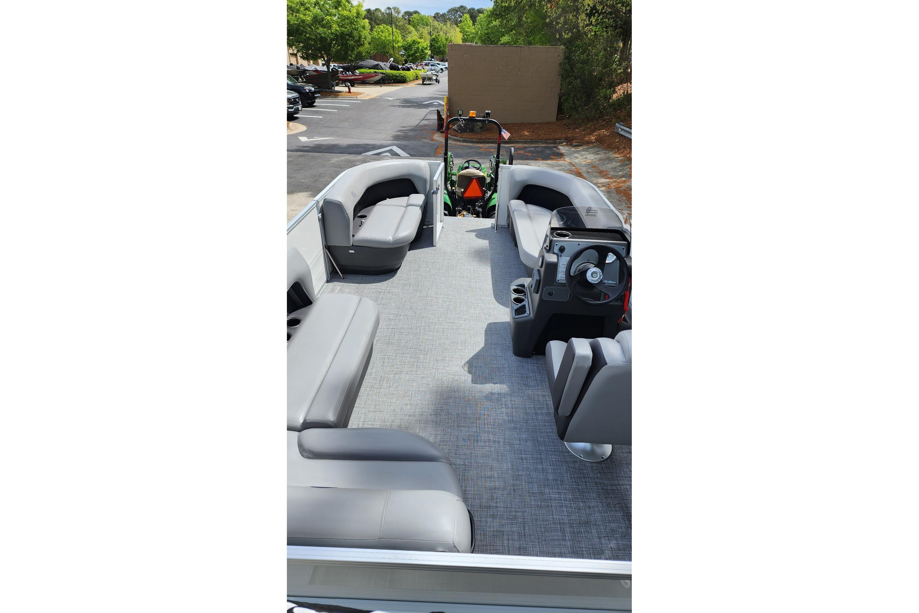 2026 Sun Tracker Party Barge 16 DLX interior with gray seating and steering console.