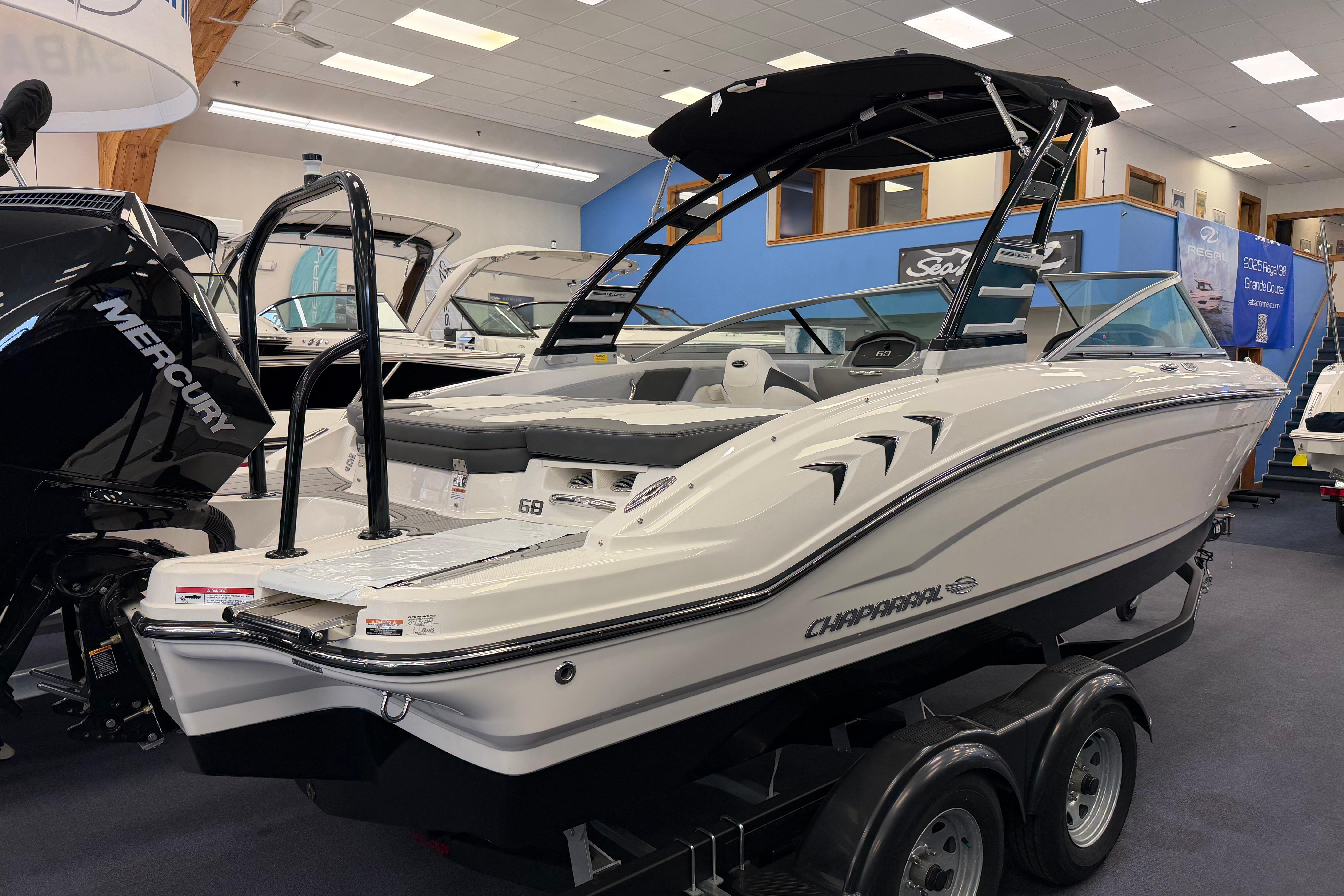 2025 Chaparral 21 SSi OB boat displayed indoors on a trailer.