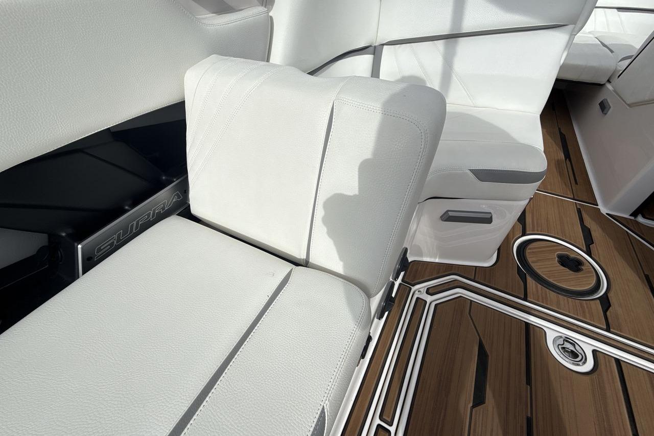 2024 Supra SA 550 boat interior with white seating and wood-style flooring.