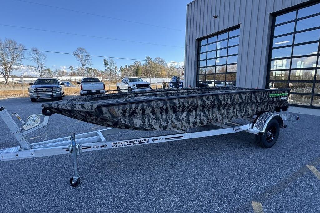 2025 Havoc 1860 boat with camouflage design on a trailer outside a dealership.