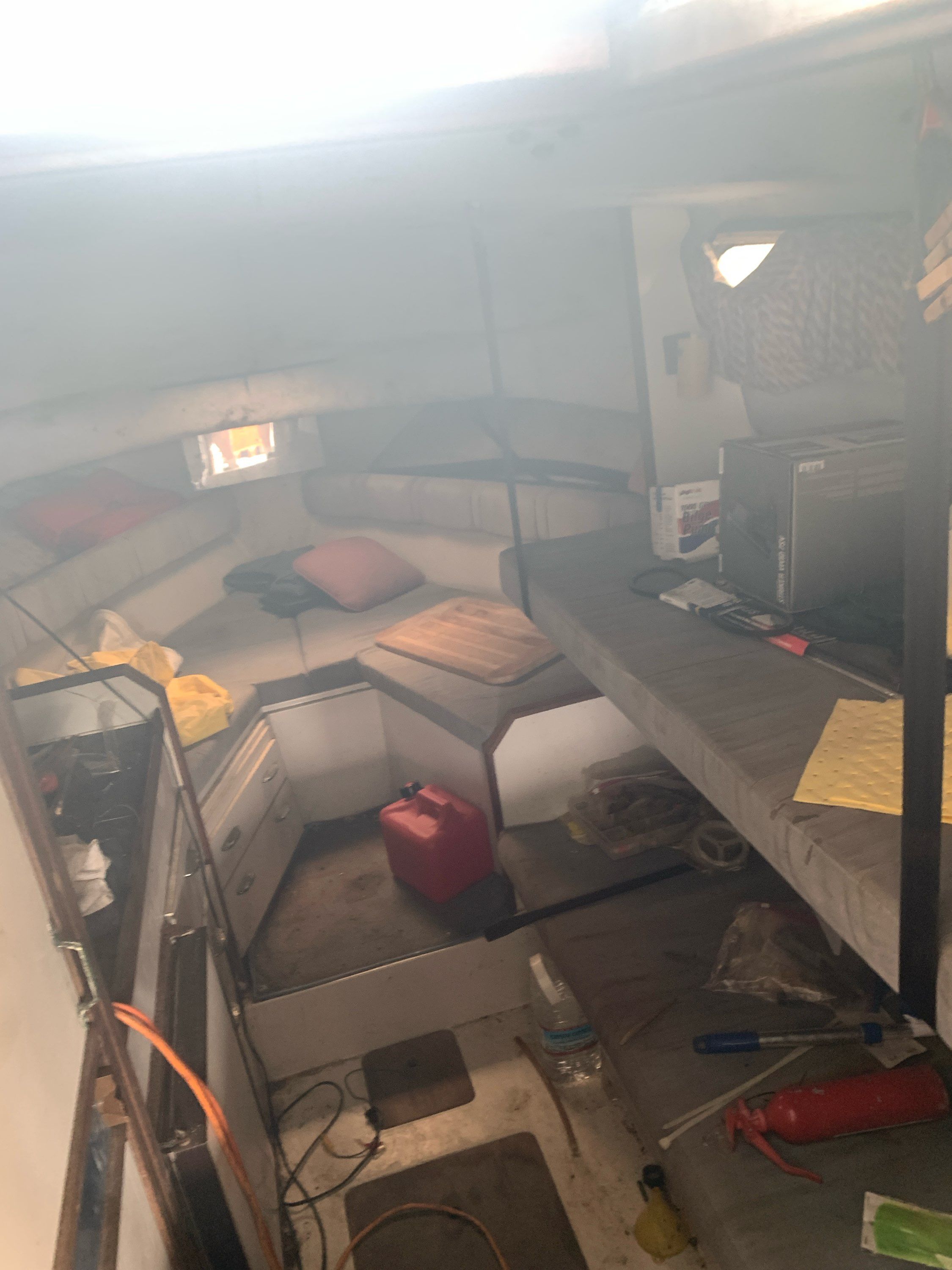 The image shows the interior of a 1987 Wellcraft Coastal boat with sleeping areas and storage.