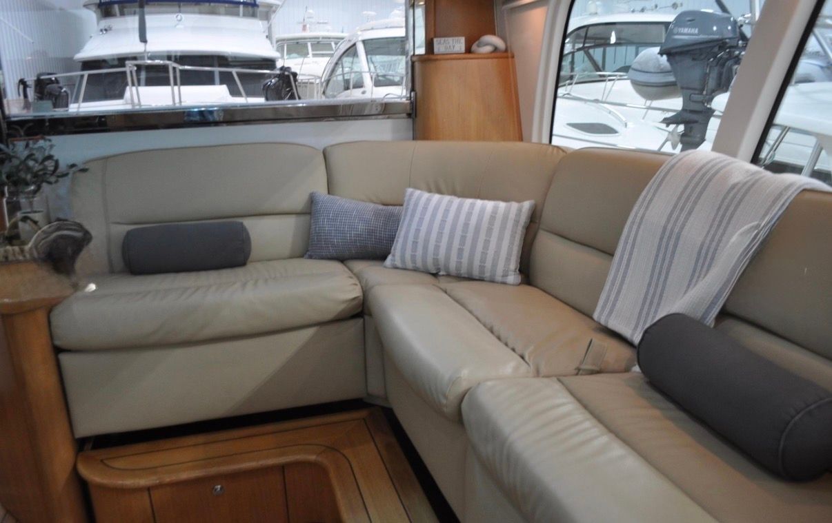 Interior of a 2005 Tiara Yachts 5200 Sovran with beige leather sofa and cushions.
