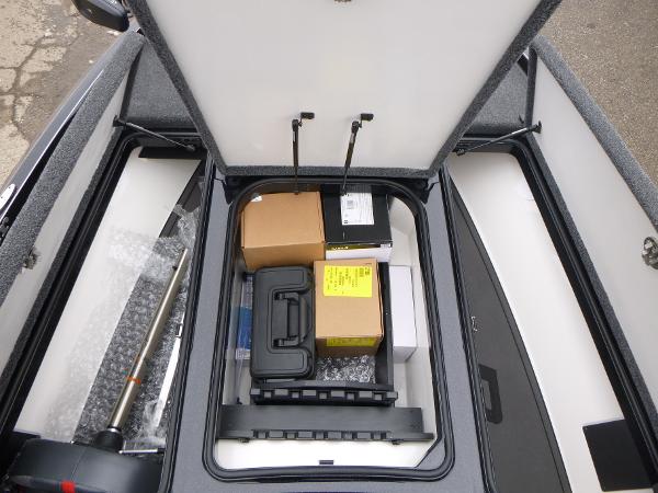 Open storage compartment in 2025 Ranger Z519R Cup-Equipped boat, containing various boxes and equipment.