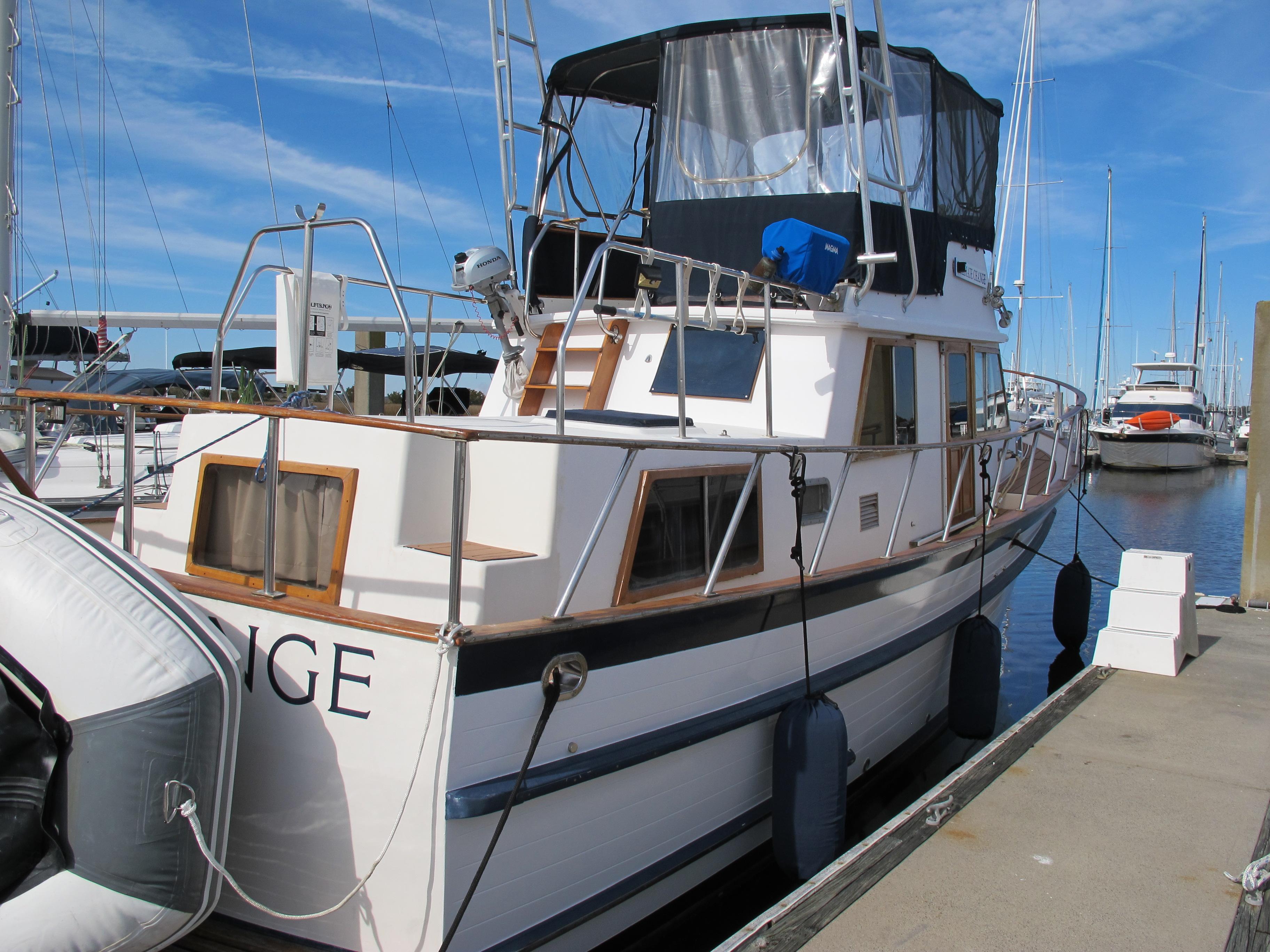 1984 Monk 36 boat docked at marina, featuring classic design and spacious deck.