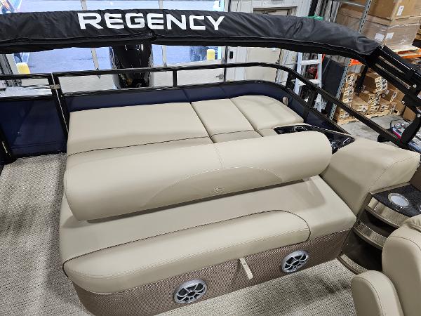 2024 Regency 250 DL3 pontoon boat with beige seating and black canopy.