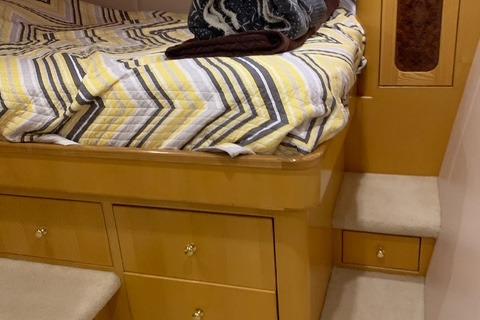 Interior of 2005 Wendon 605 yacht with cozy bed and wooden cabinetry.