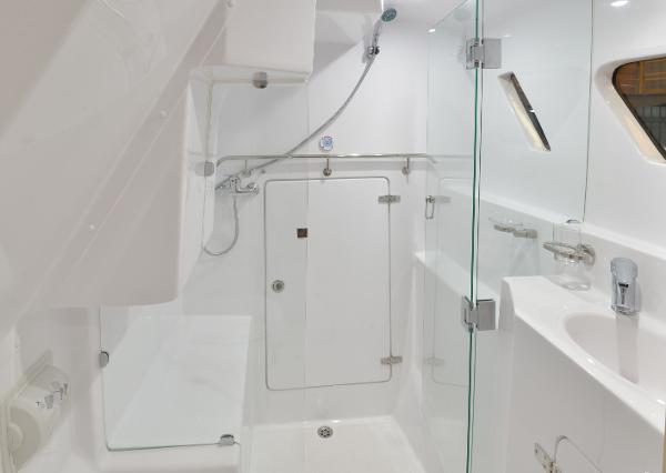 Modern bathroom in 2025 Seawind 1170 yacht with glass shower and sleek fixtures.