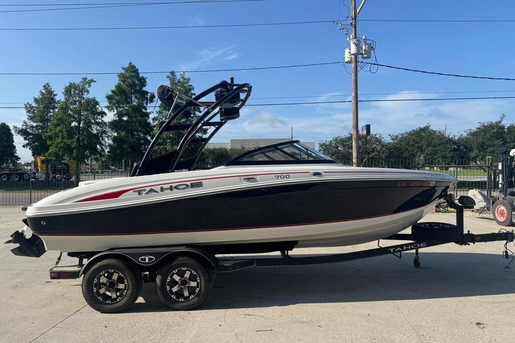2018 Tahoe 700 TF boat on trailer, black and white design, parked outdoors.