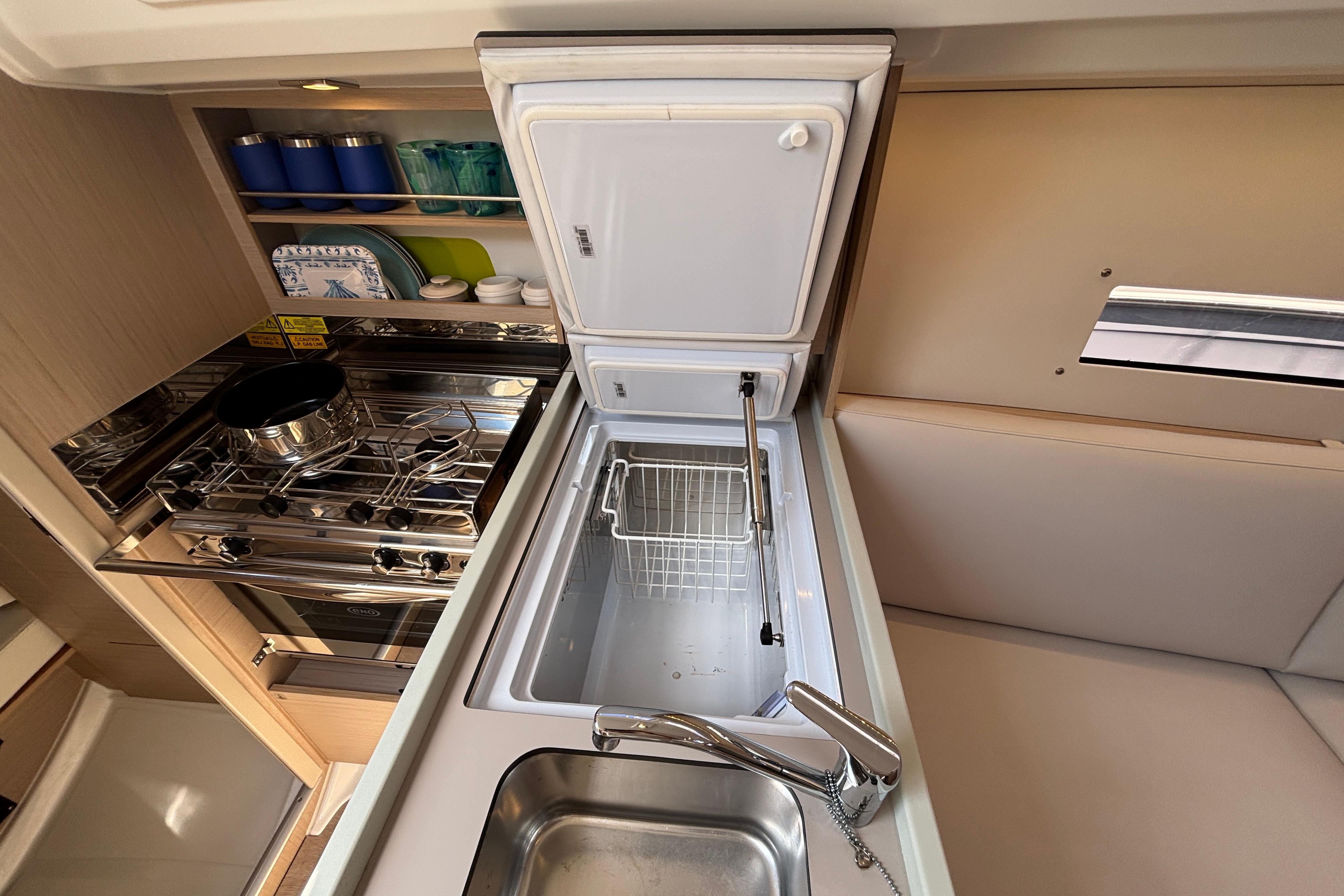 Modern kitchen area in a 2021 Beneteau Oceanis 30.1 yacht, featuring stove and sink.