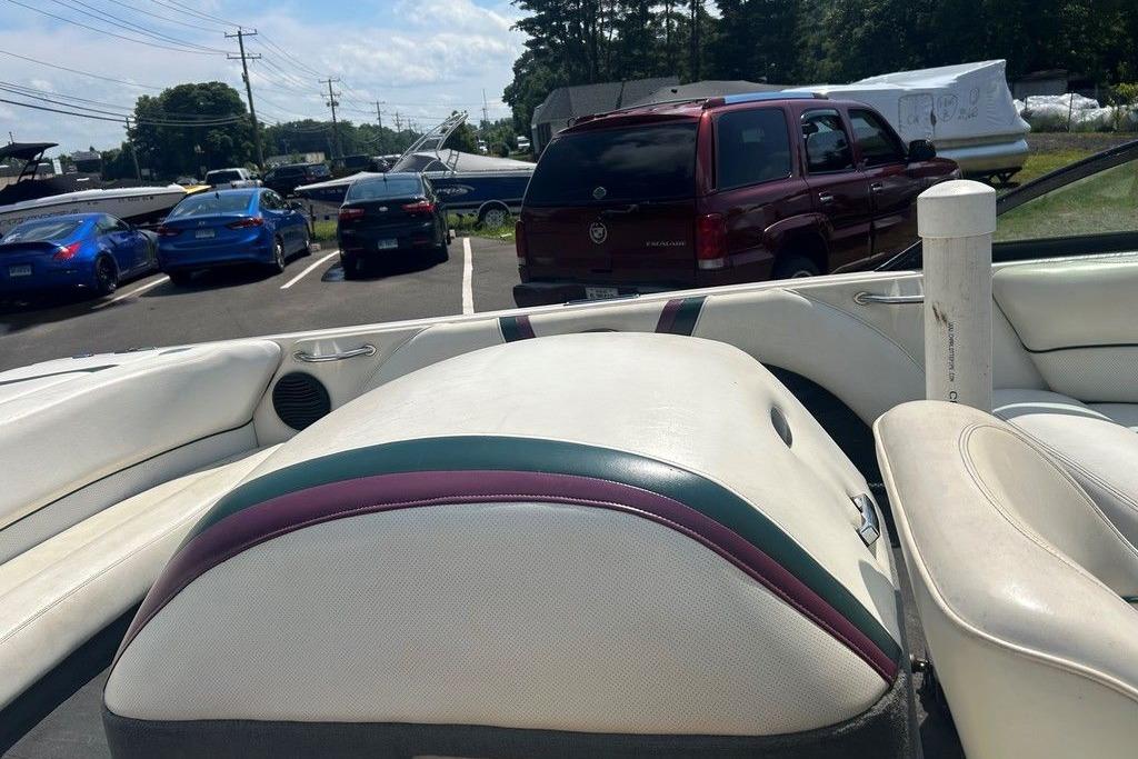 1999 Malibu Response boat interior with white and maroon seats in a parking lot.