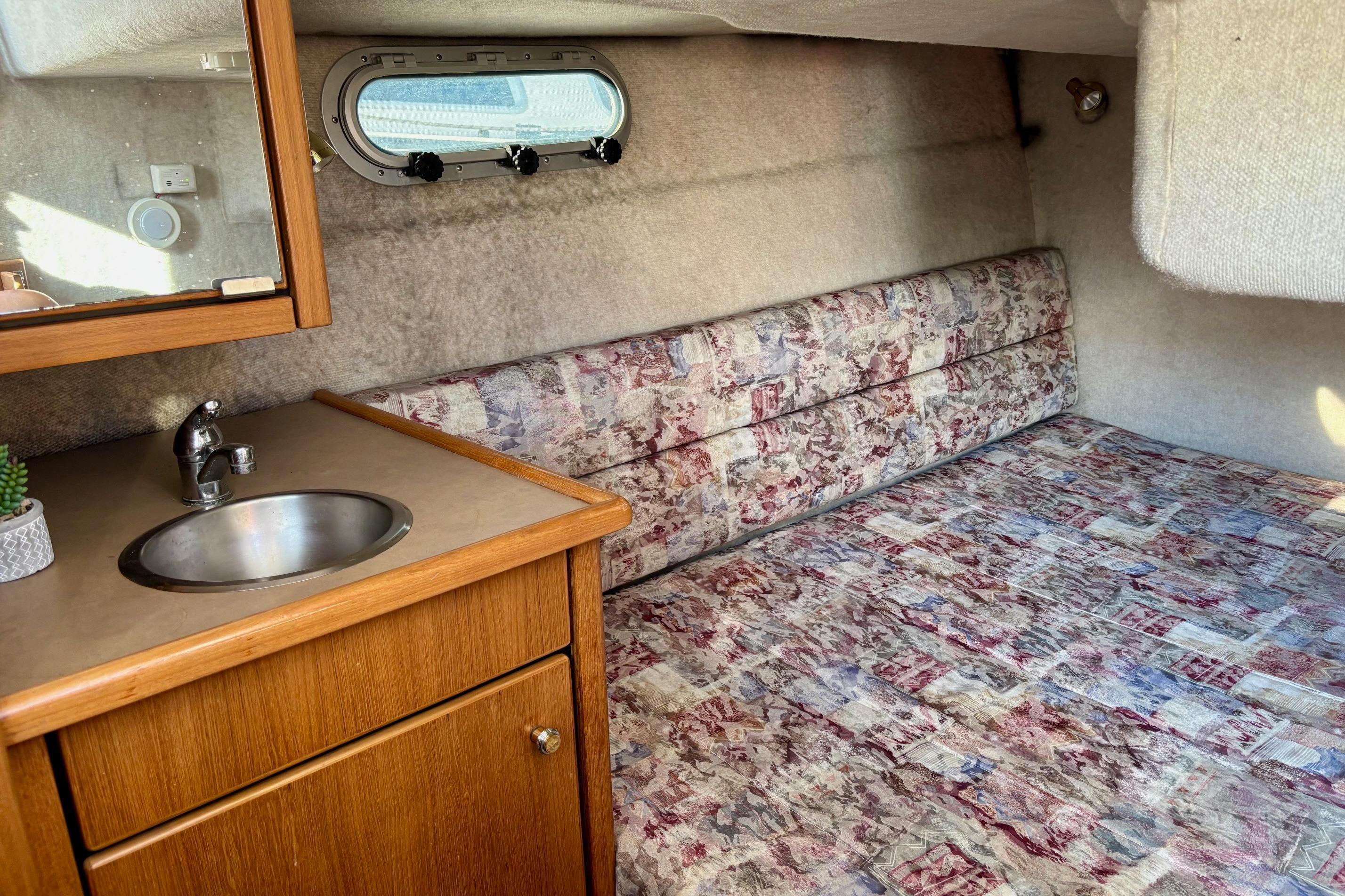 1998 Bayliner 3388 Command Bridge Motoryacht interior with sink and patterned bedding.