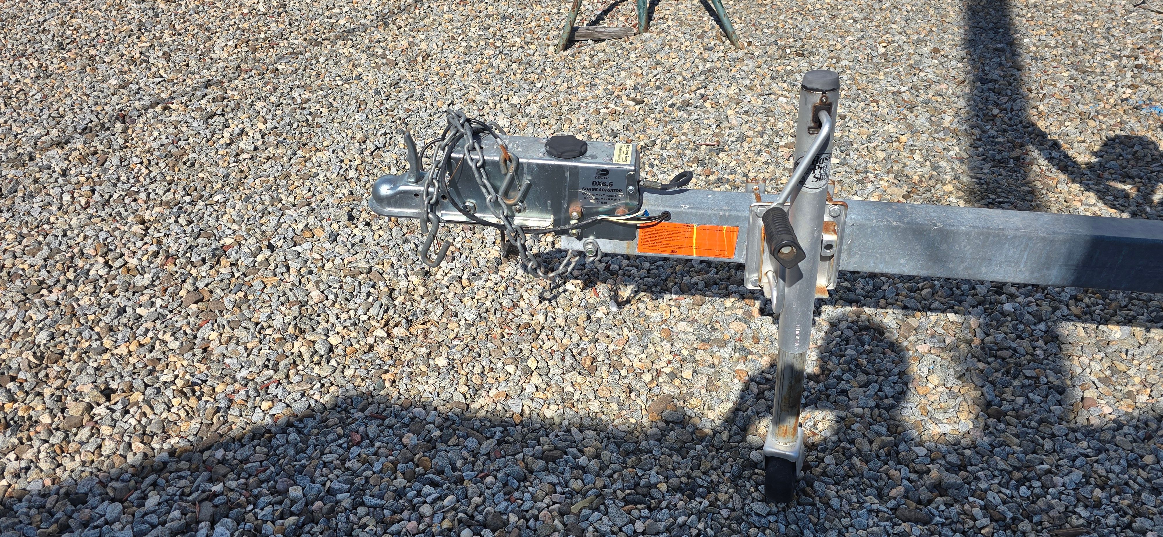 Trailer for a boat on a gravel surface.