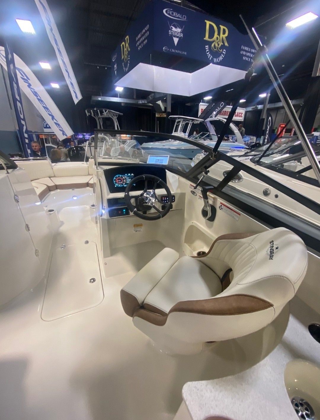 The image shows the cockpit of a Stingray 231 DC boat at a trade show.
