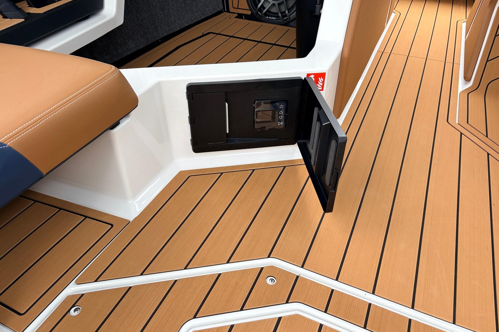2026 Nautique Super Air Nautique G25 interior with teak flooring and storage compartment.