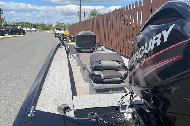 2019 Tracker Panfish 16 boat with Mercury engine, parked near a wooden fence.