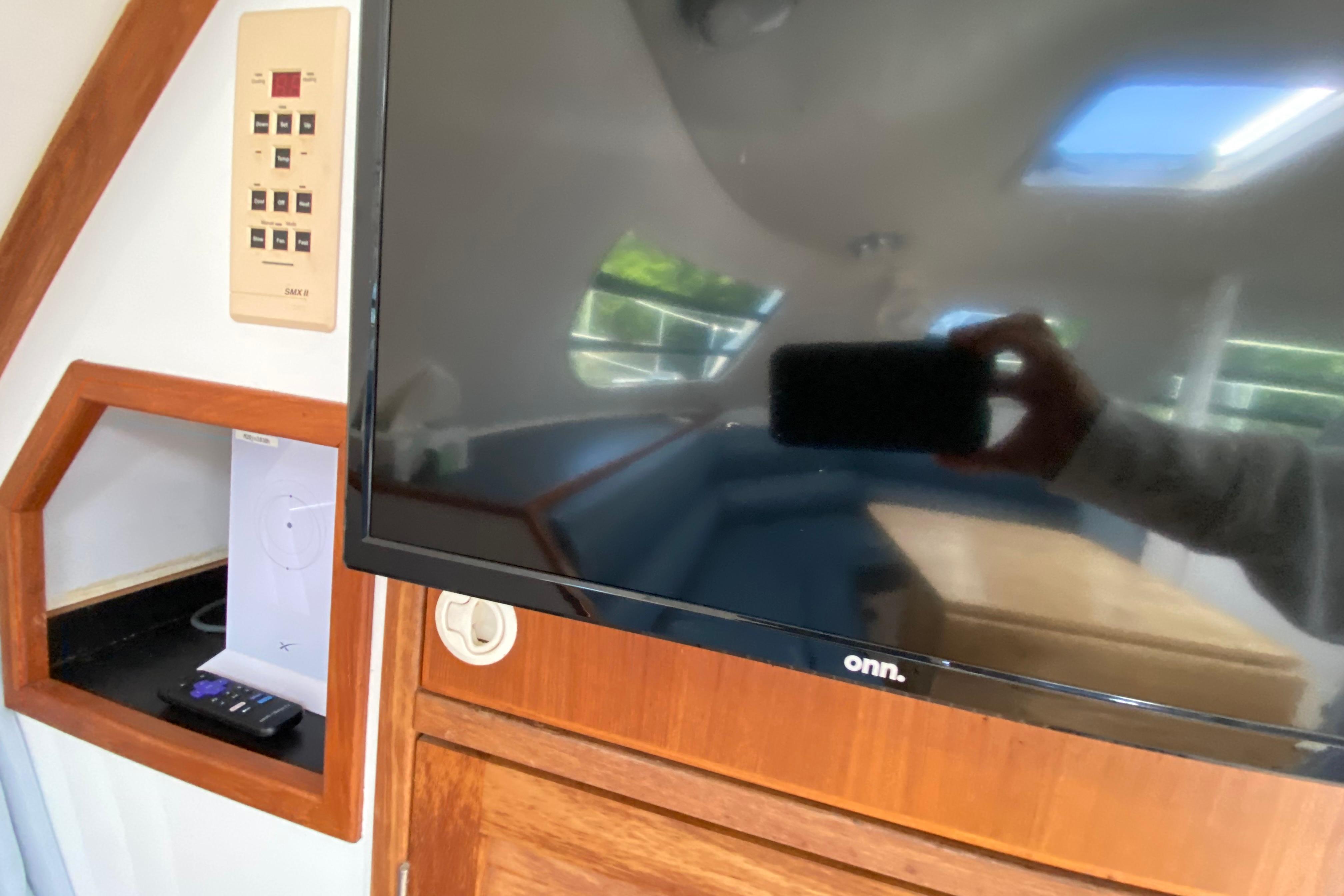 Interior of a 1998 Manta 40 yacht featuring a mounted TV and control panel.