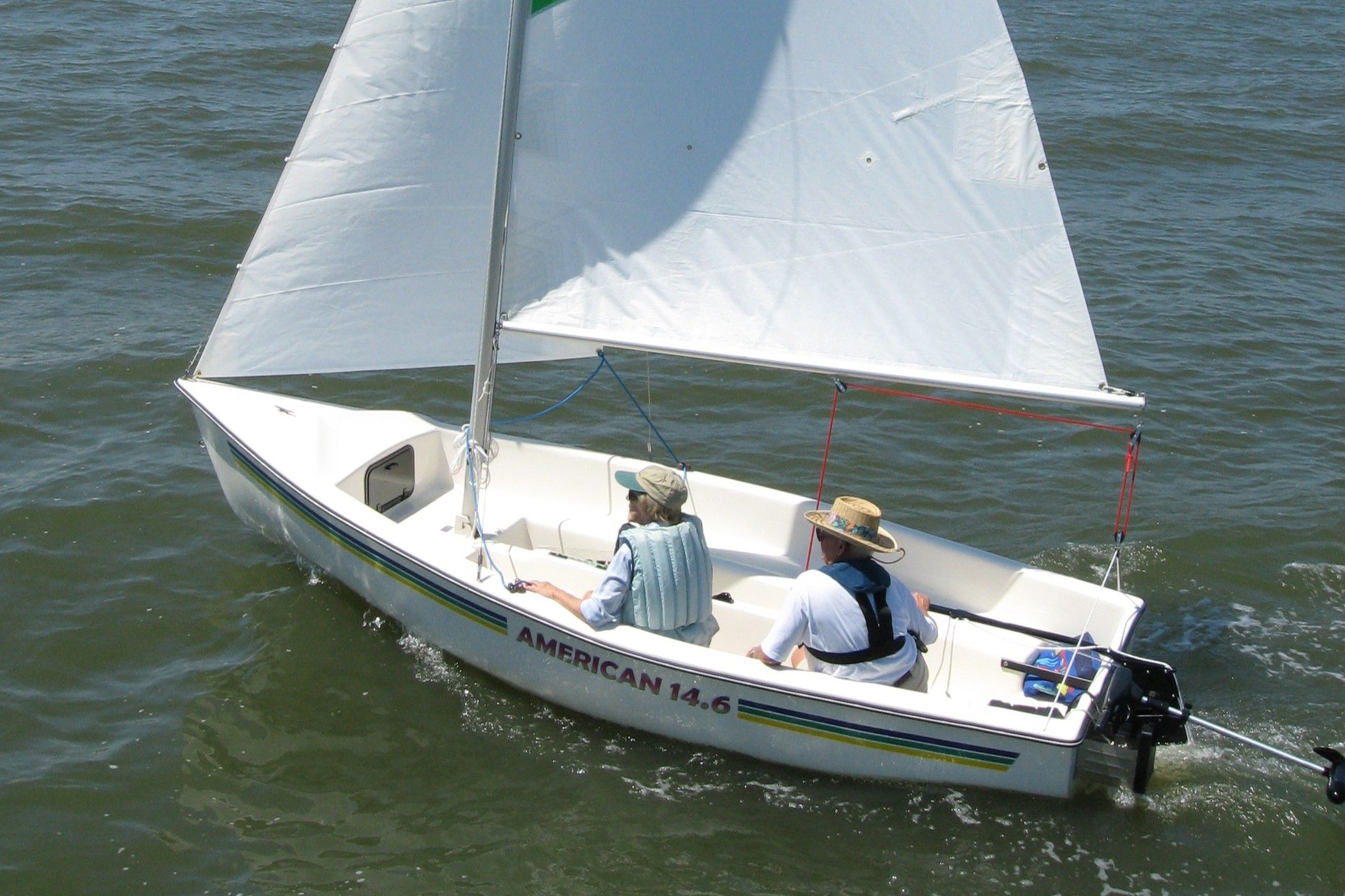 American 14.6 sailboat on water with two people aboard.