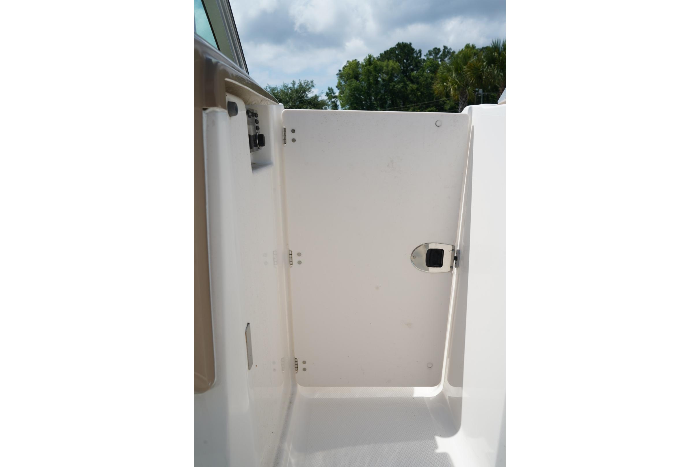 2013 Chaparral 206 SSi boat interior door with latch, under a cloudy sky.
