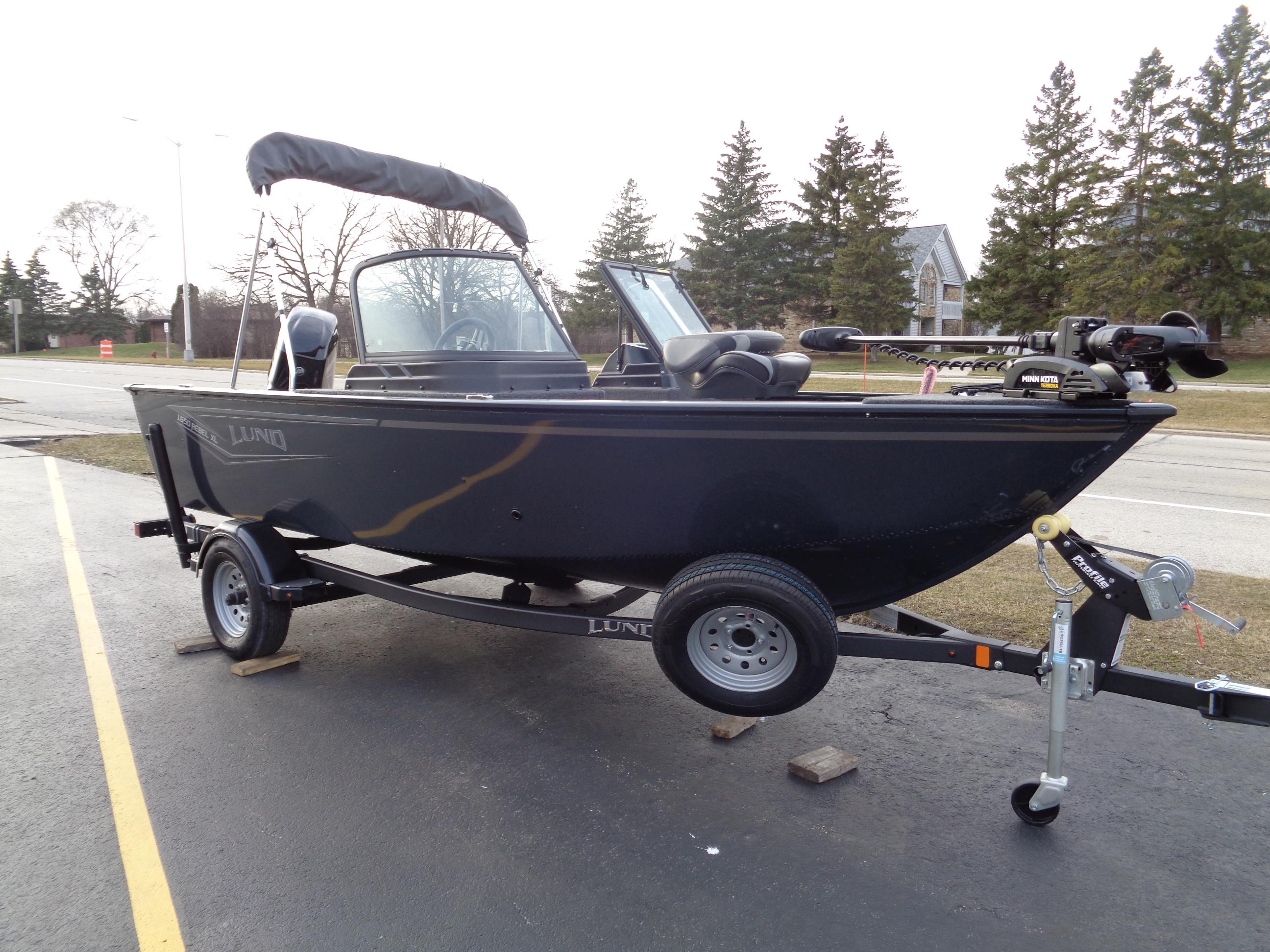 2024 Lund 1650 Rebel XL Sport boat on trailer, parked outdoors.
