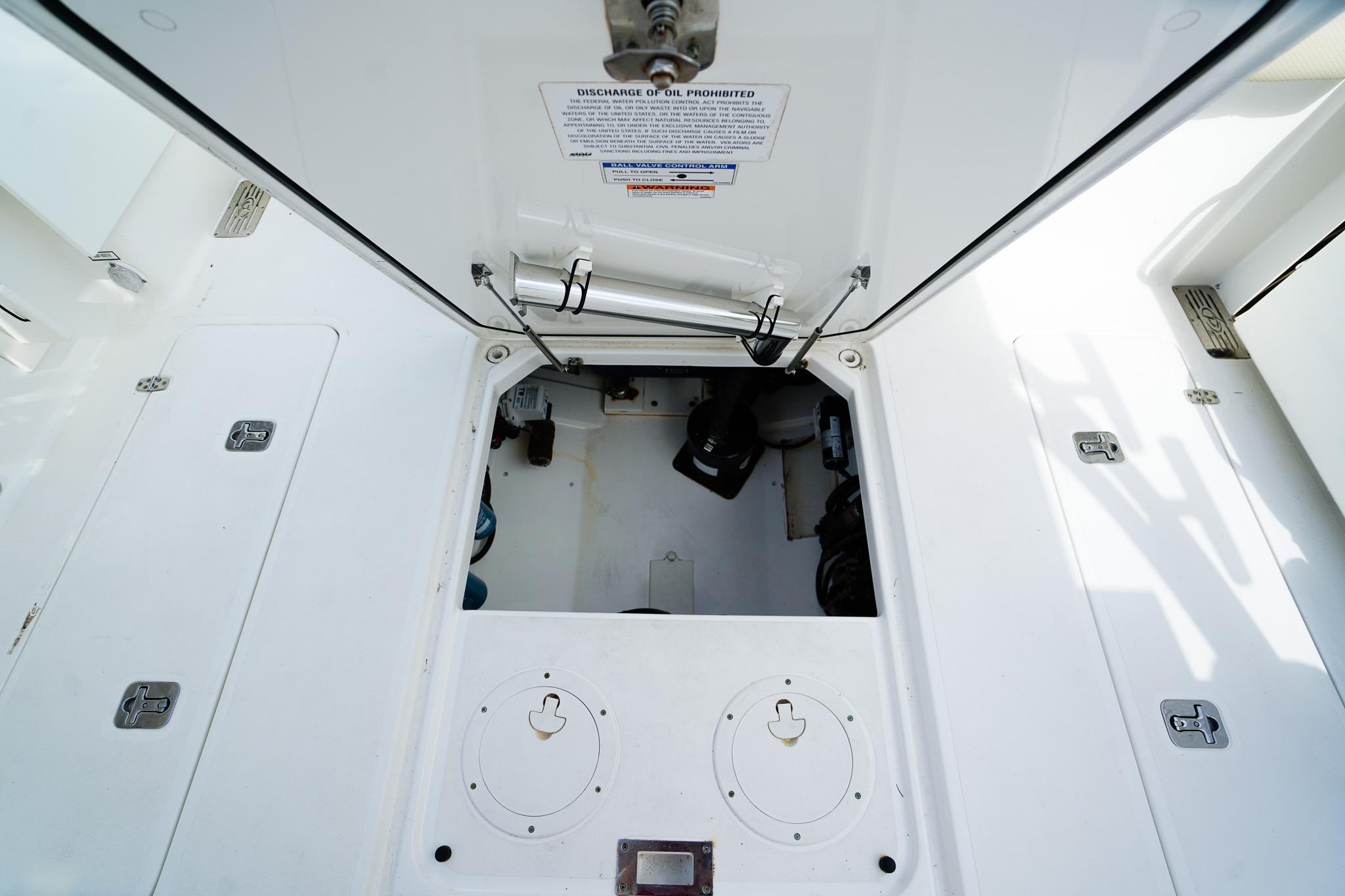 Engine compartment of a 2020 Pursuit OS 325 Offshore boat, showcasing storage and access hatches.