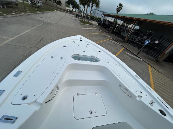 2024 Sea Pro 250 DLX boat, spacious deck, parked outdoors.