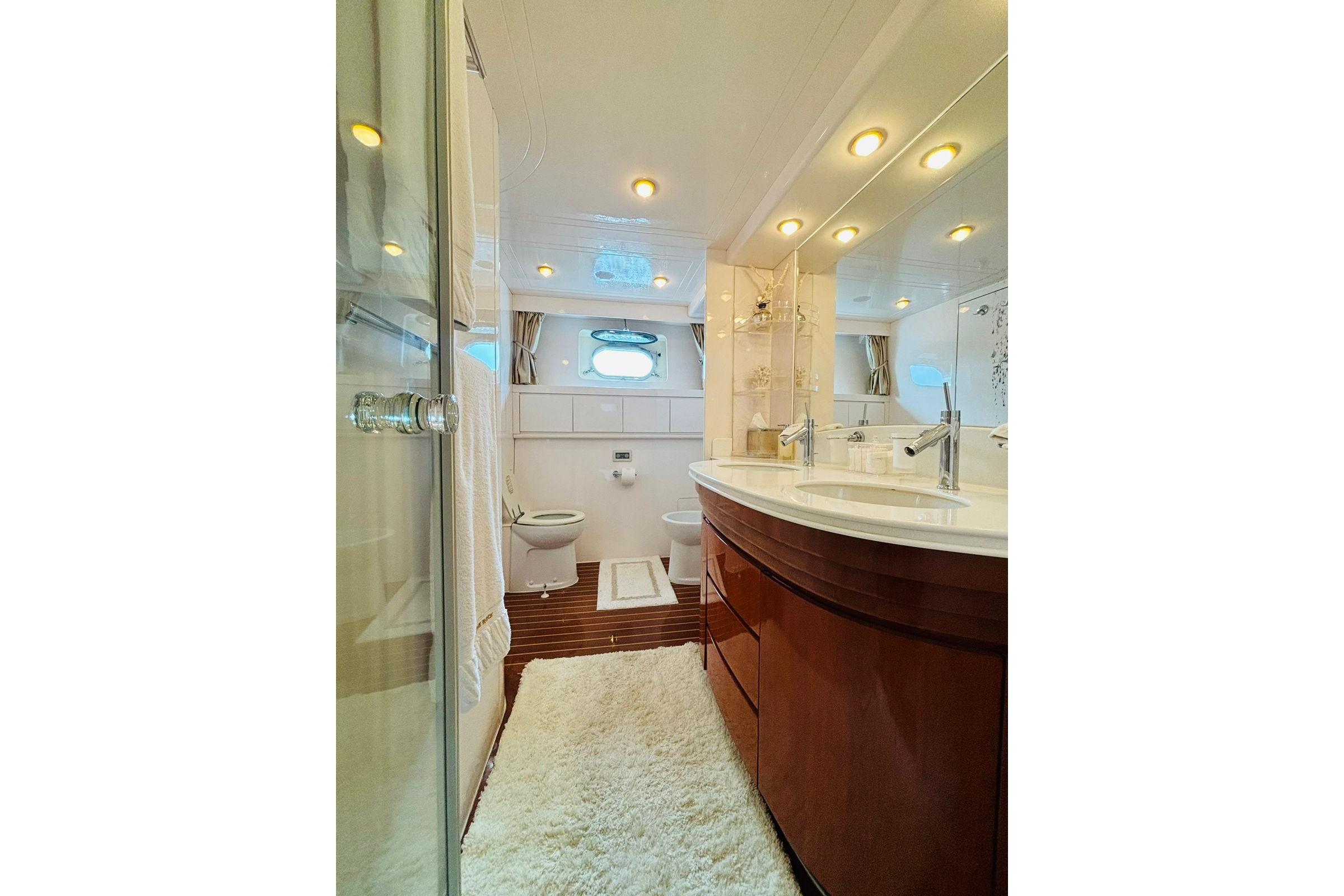 Luxurious yacht bathroom with double sinks, elegant lighting, and modern fixtures in Falcon 100, 2000 model.
