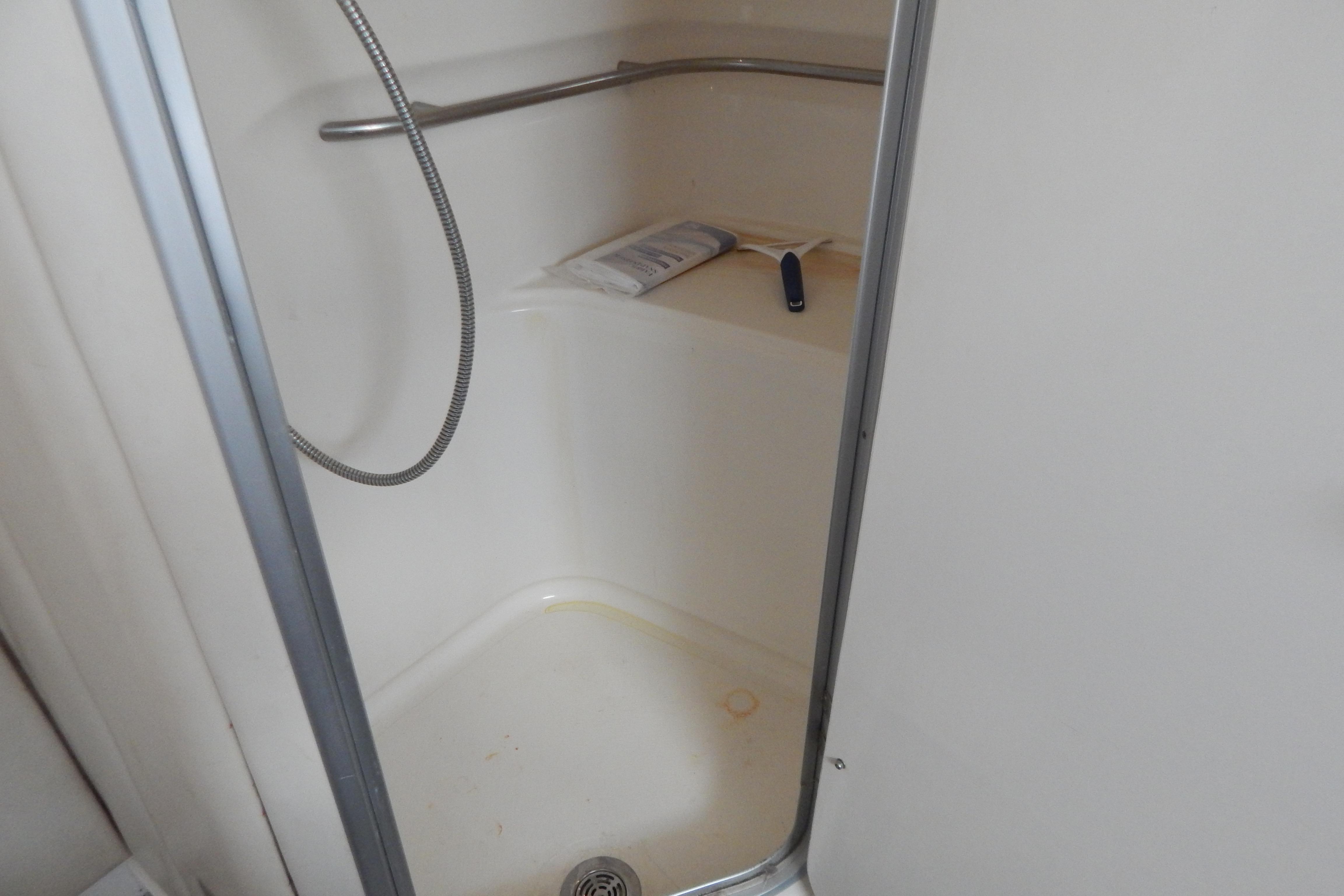 Shower area inside a 1998 Magnum 4100 SCR boat, featuring a handheld showerhead.