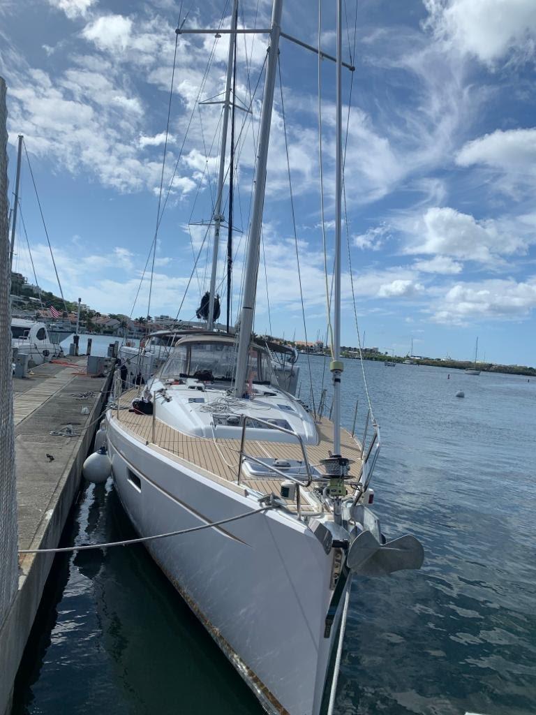 2015 Jeanneau Sun Odyssey 469 sailboat docked in a marina under a partly cloudy sky.